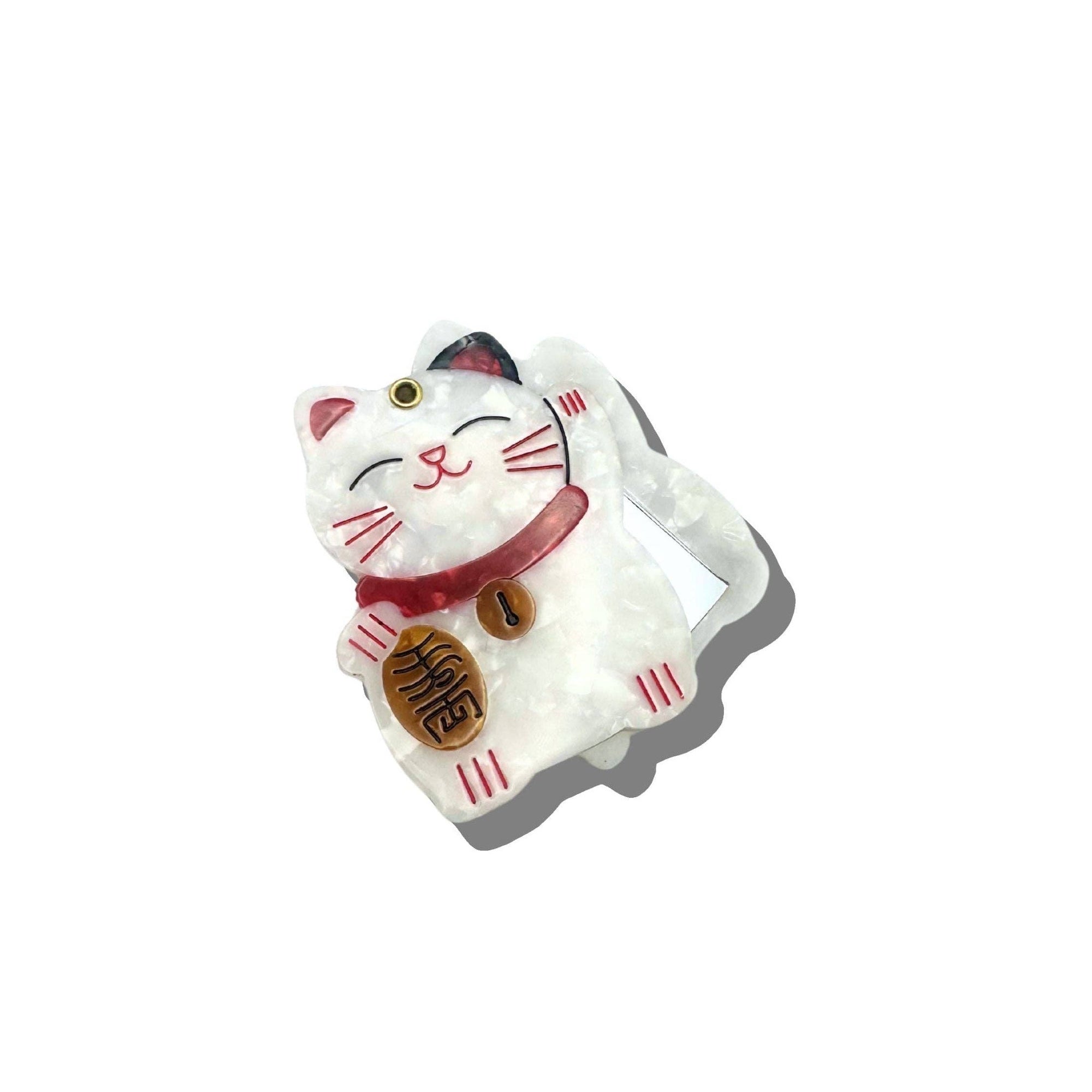 White cat-shaped figurine with red accents on a white background