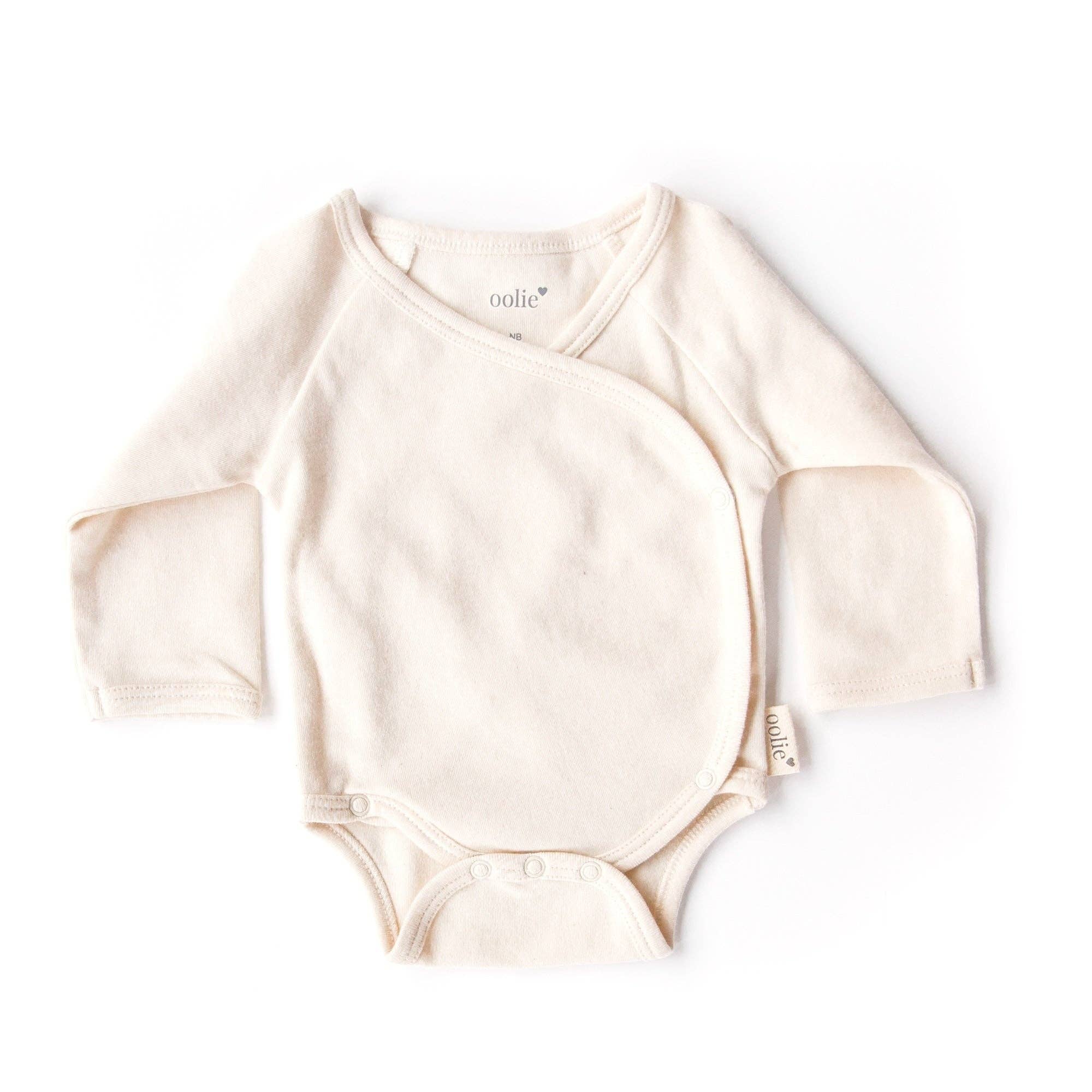 Beige baby onesie with long sleeves on a white background