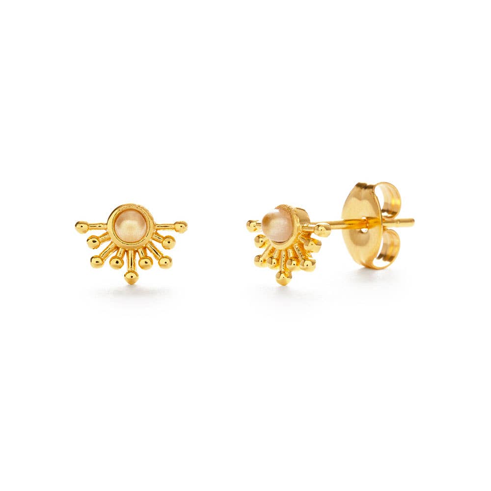 Gold sun-shaped earrings with a central gemstone on a white background