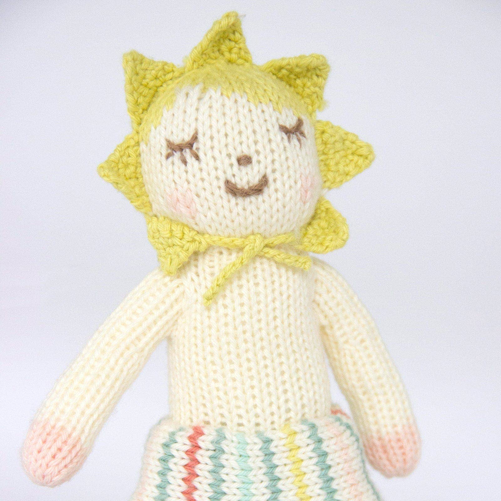 Knitted doll with a yellow flower hat on a white background
