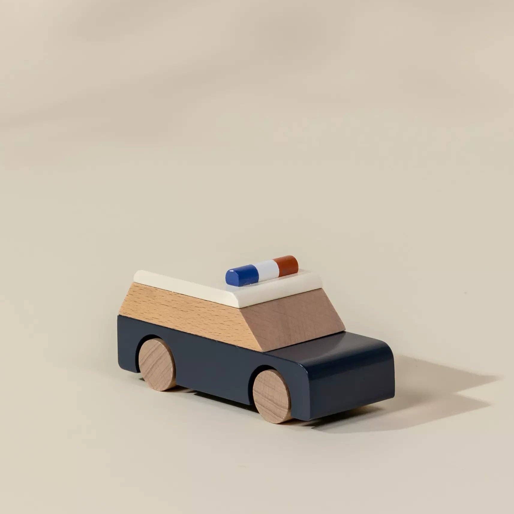Wooden toy car with a blue light on a beige background