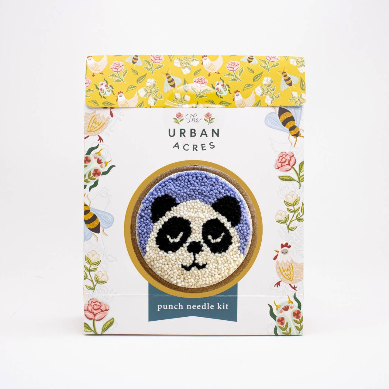 The Urban Acres punch needle kit in its illustrated packaging, featuring a panda face made of white and purple punch needles in the center of the box.