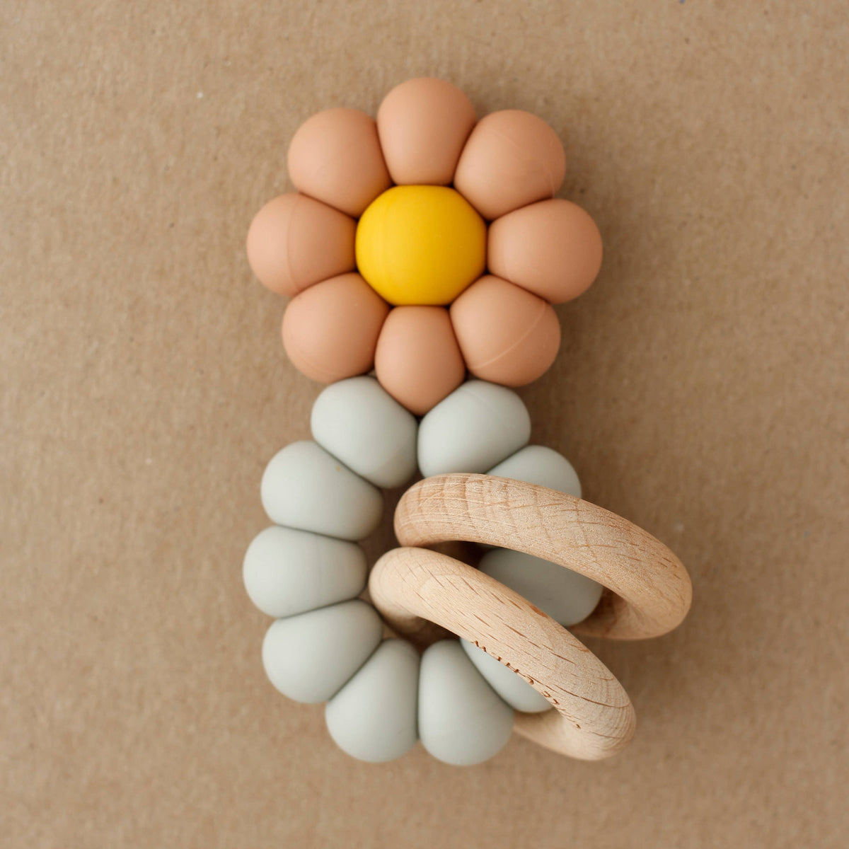 Baby teething ring with flower design on a brown background