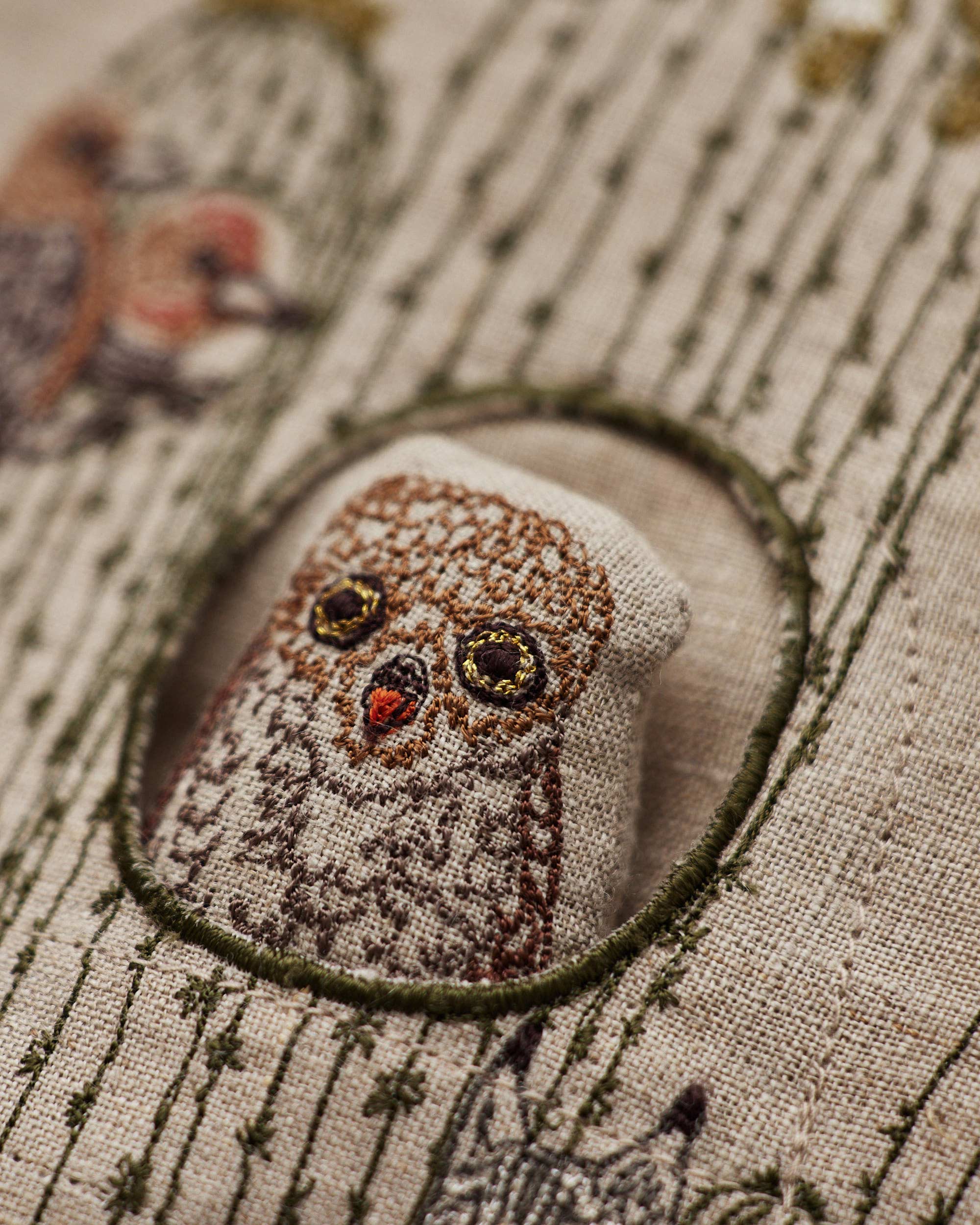 Embroidered owl design on fabric with a close-up view
