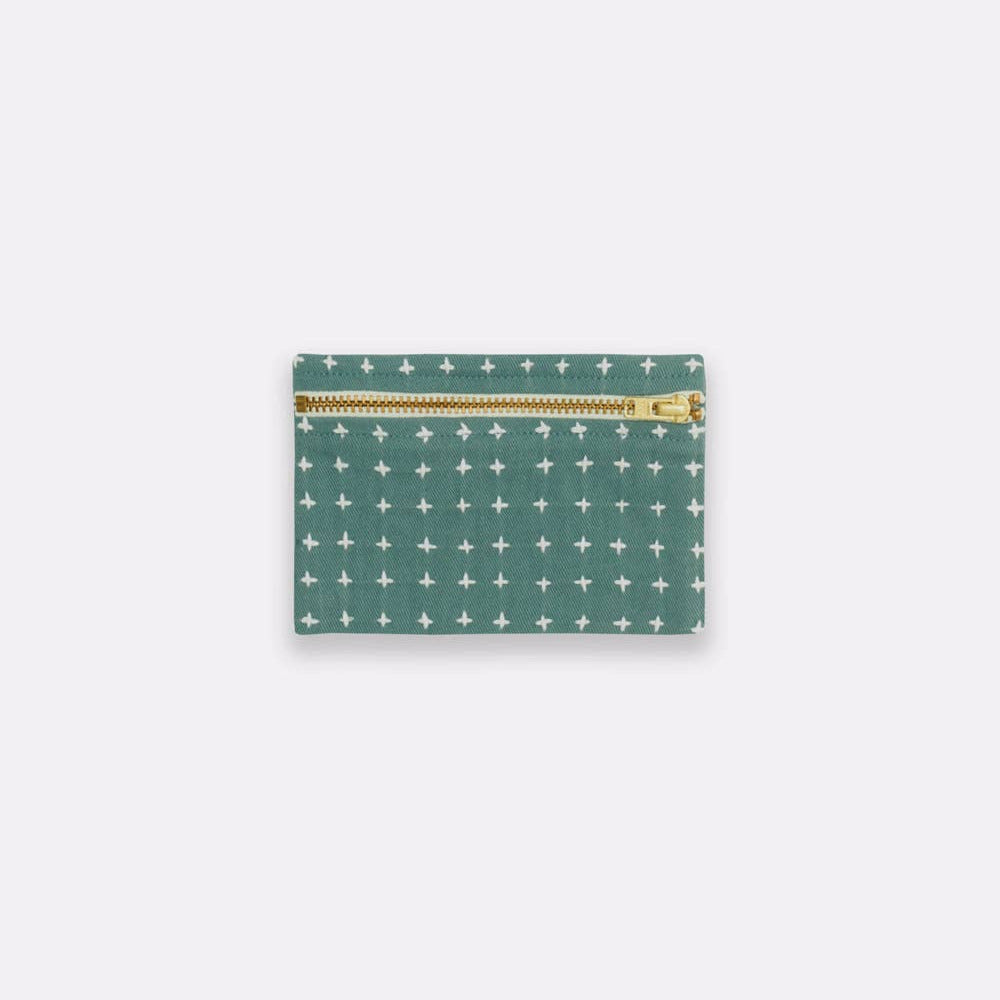 Green pouch with white star pattern and gold zipper on a light gray background