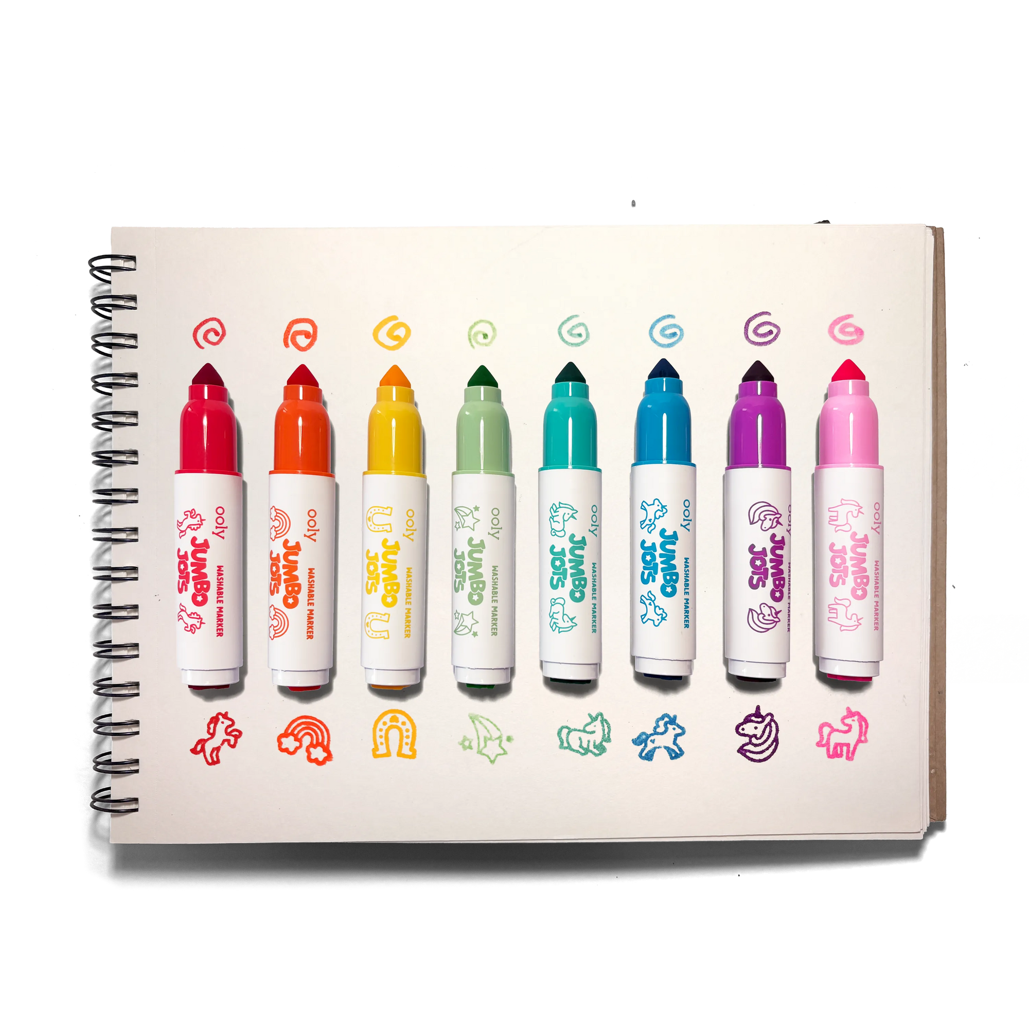Set of colorful markers with a notebook on a white background