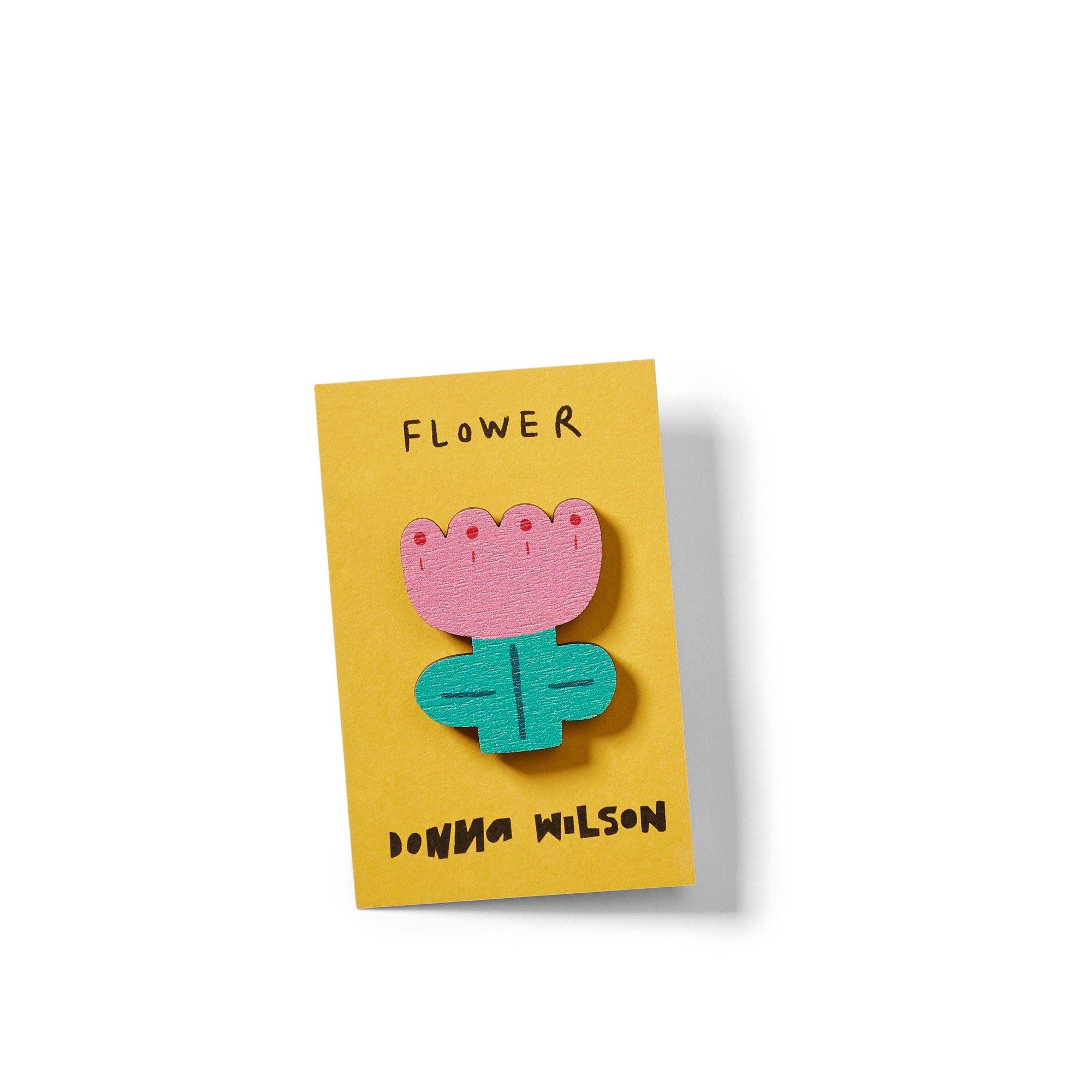Flower-shaped brooch on a yellow card with 'DONNA WILSON' branding