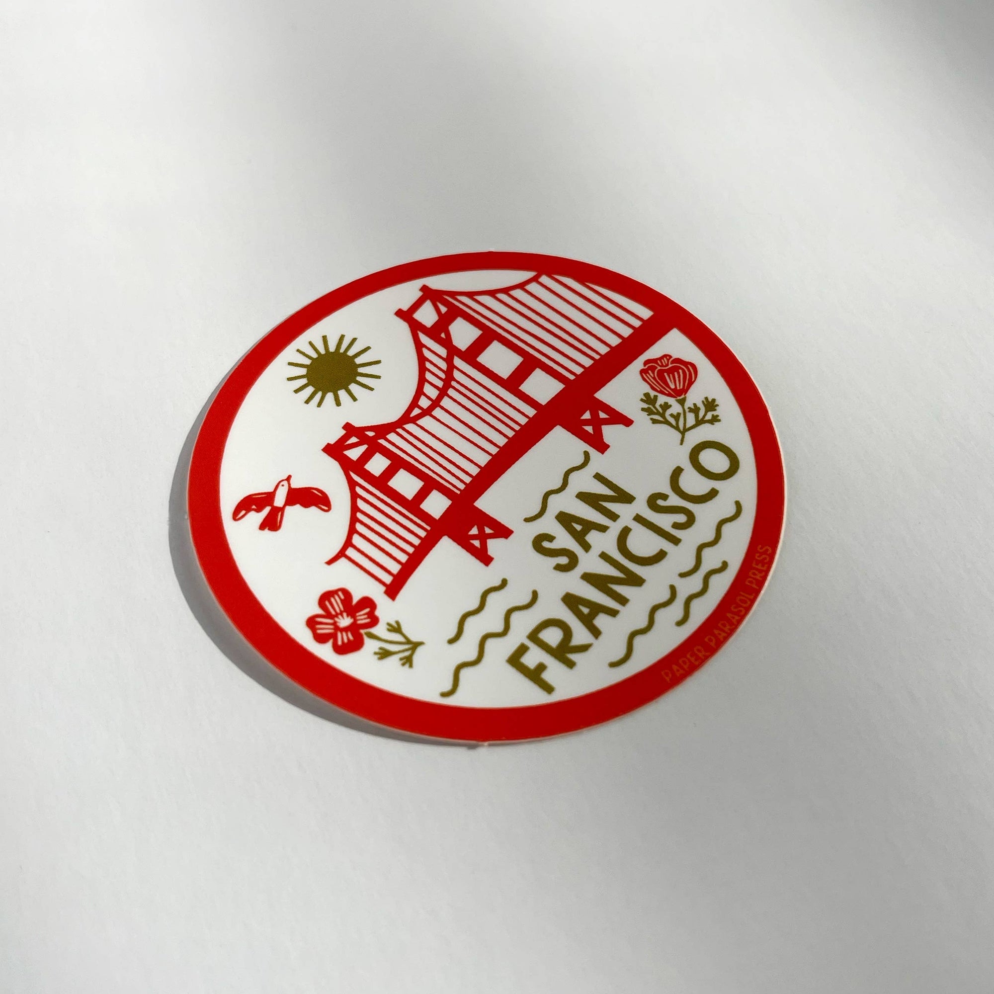 Circular sticker with red and green design on a white background