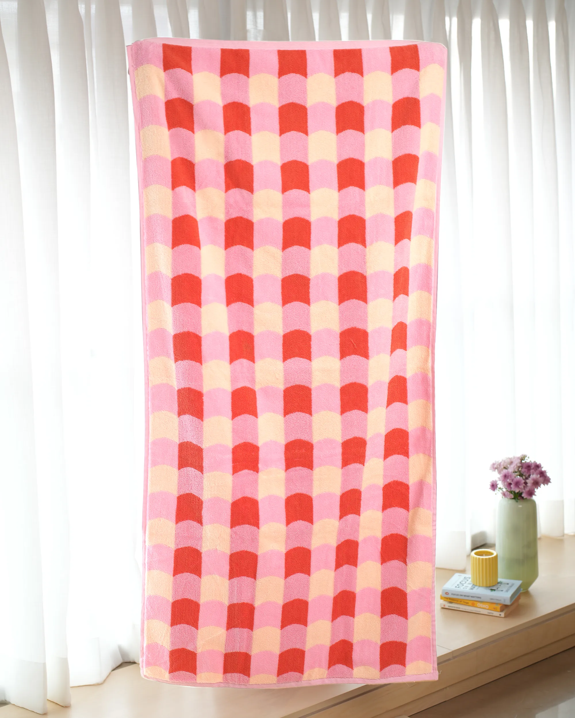 Checkered towel with red and pink pattern on a white background