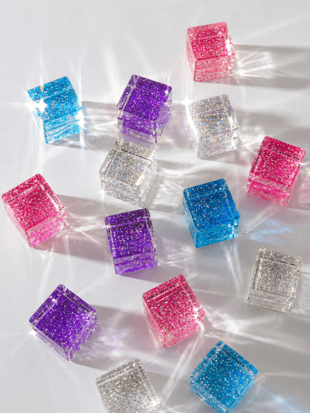 Colorful glittery cube-shaped objects on a white background