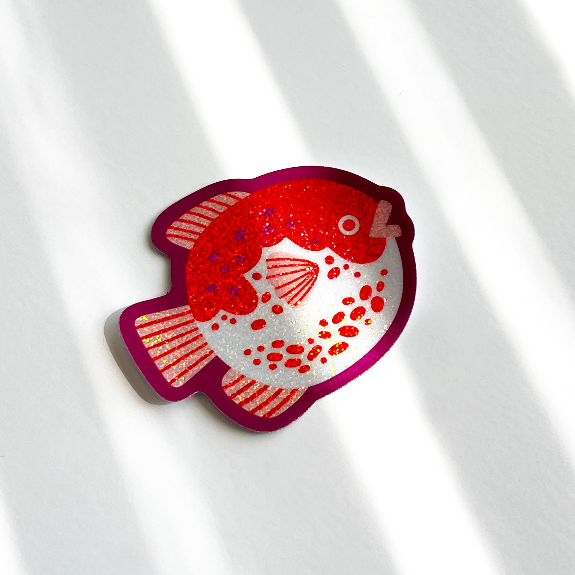 Red and white fish-shaped object on a light gray background