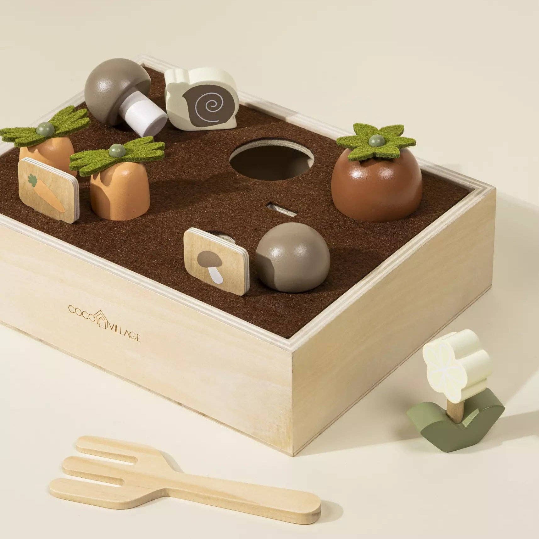 Wooden toy set with vegetables and a box on a beige background
