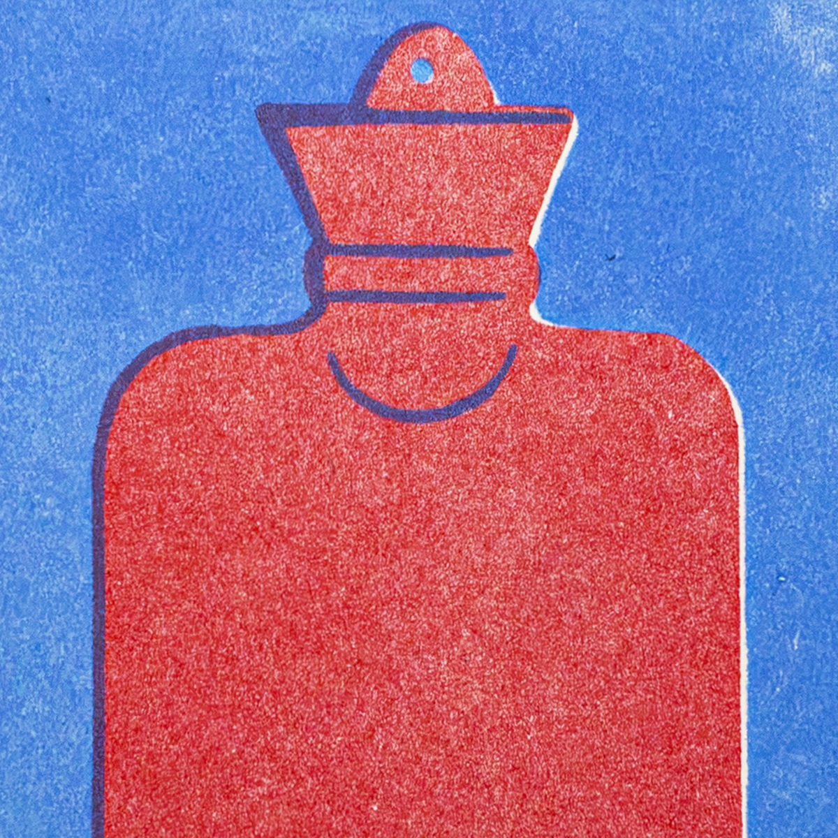 A red hot water bottle with a textured finish, shown from the front against a solid blue background.