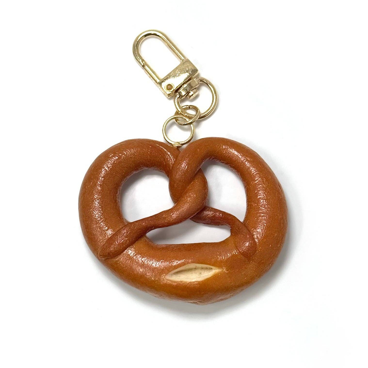 Brown pretzel-shaped keychain with a gold clasp on a white background