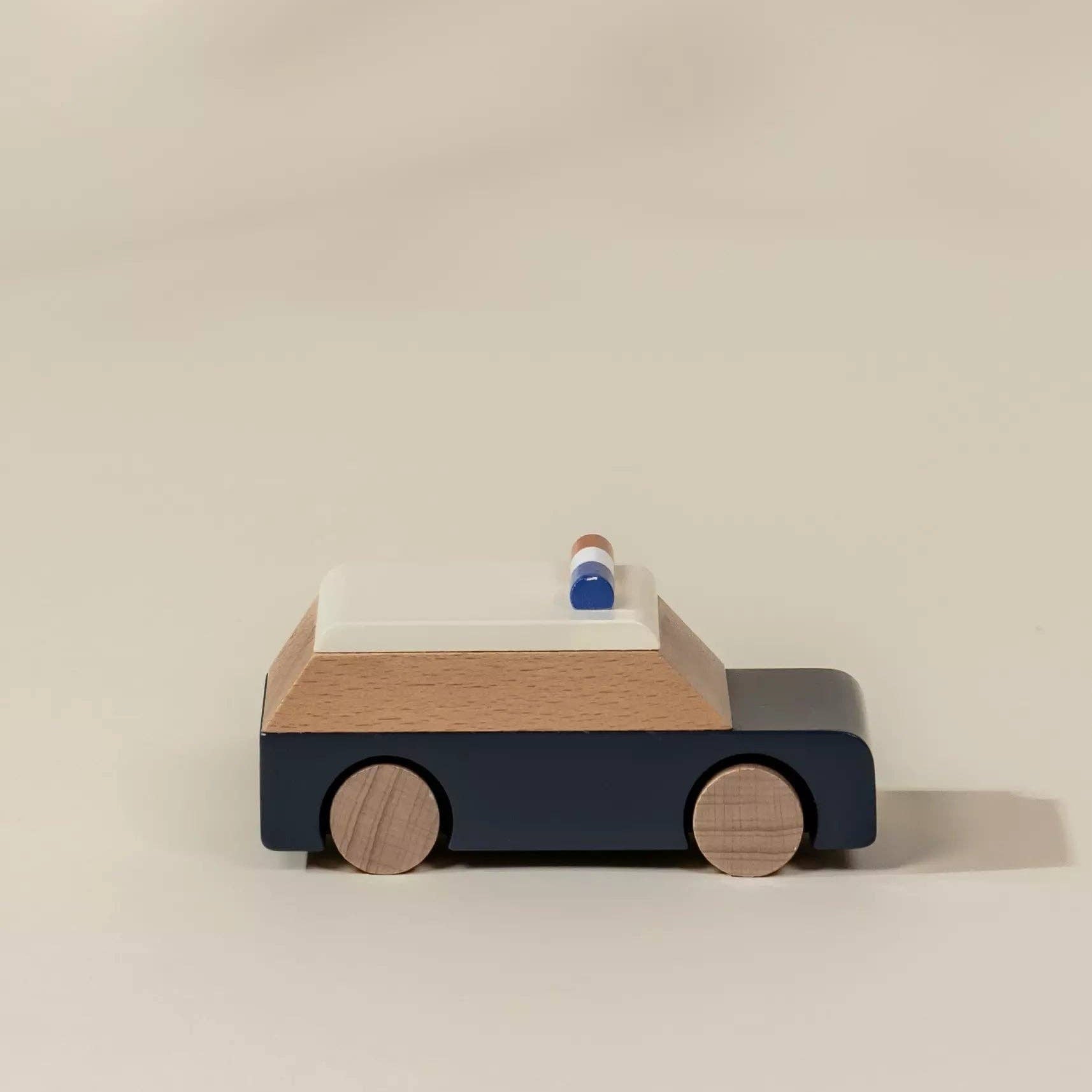 Wooden toy car with a blue body and brown wheels on a beige background