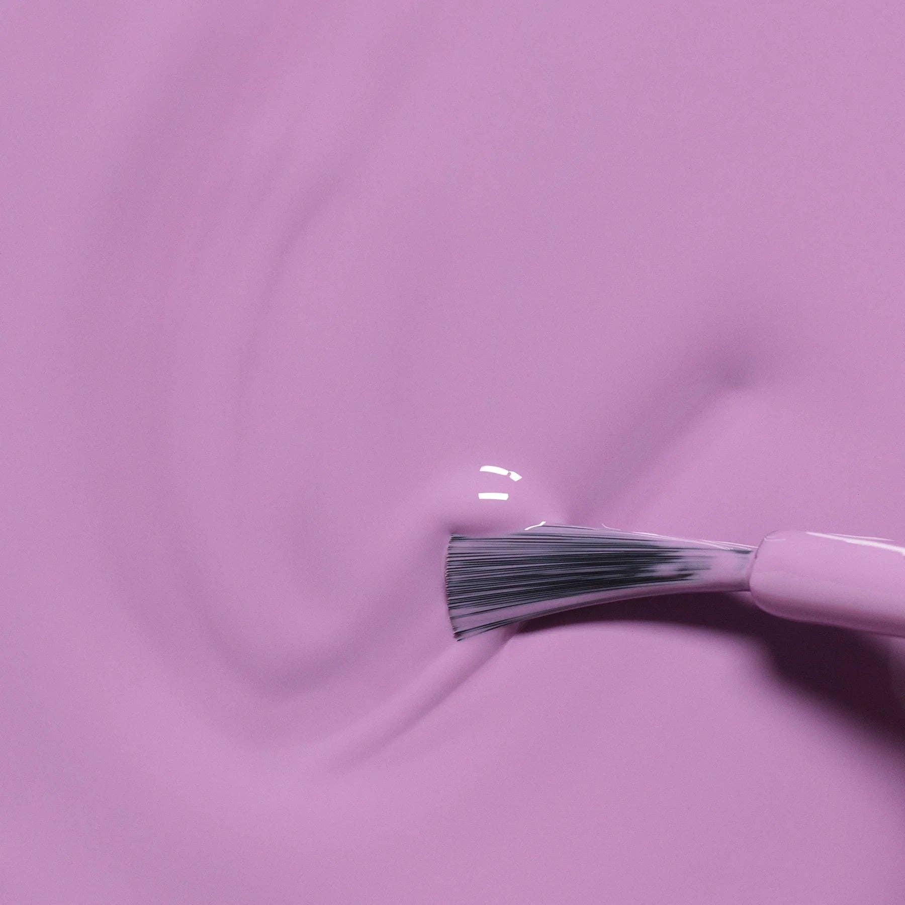 Makeup brush with pink handle on a matching pink background