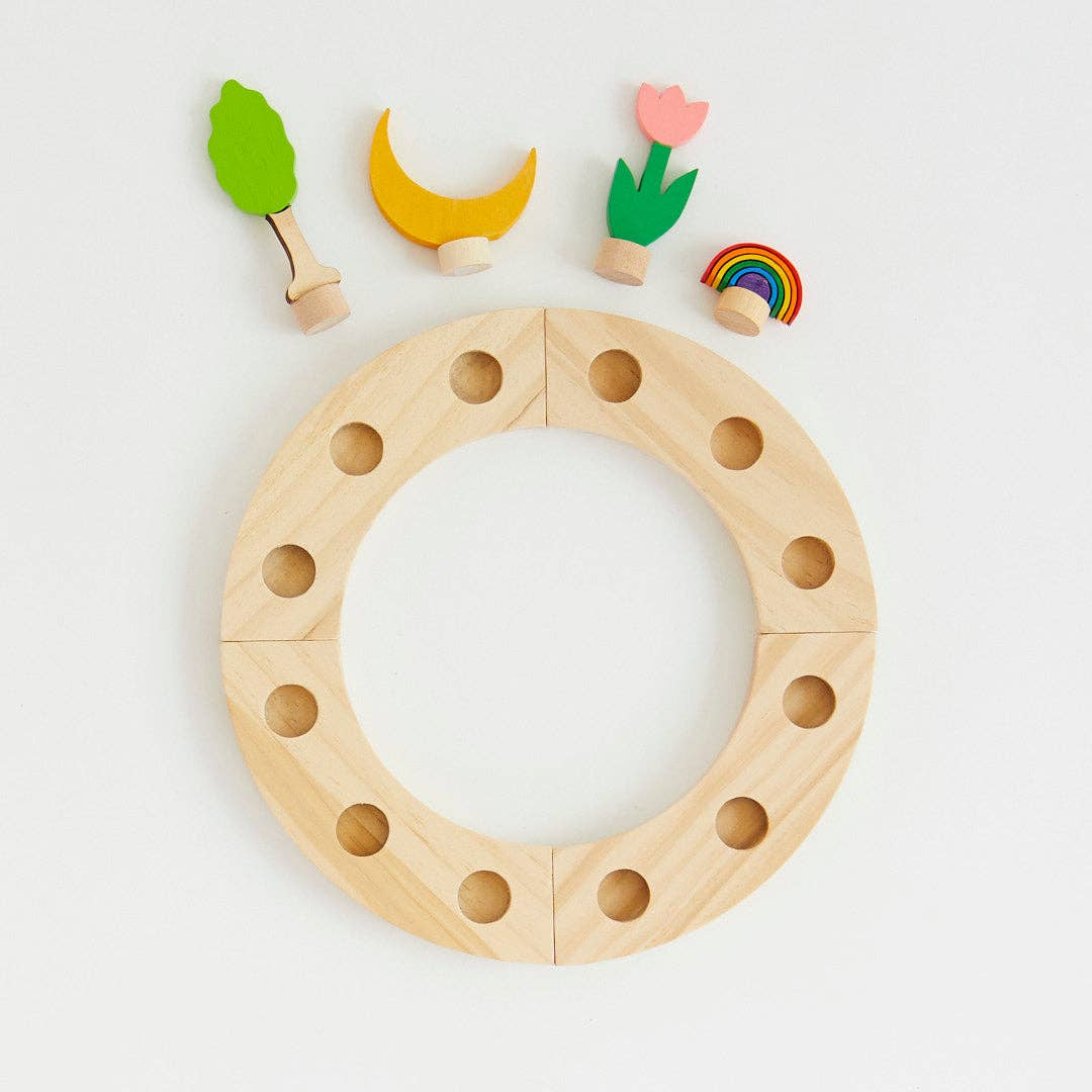 Wooden toy ring with colorful wooden pieces on a light gray background