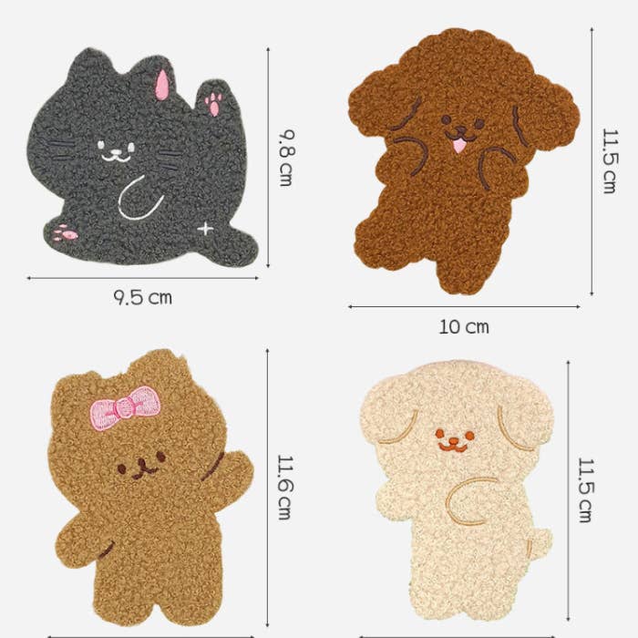 Four cartoon-shaped stickers shown on a light gray background with dimension lines and measurements. The mats feature a black cat, a brown curly-haired dog, a tan bear with a pink bow, and a cream-colored puppy.