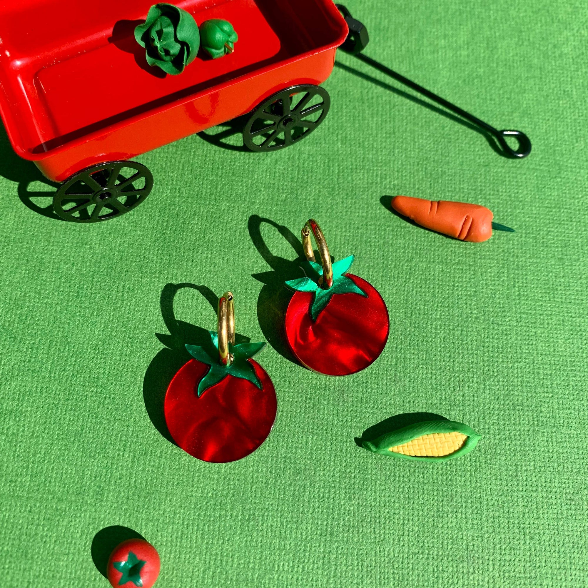 Red toy wagon with toy vegetables on a green background