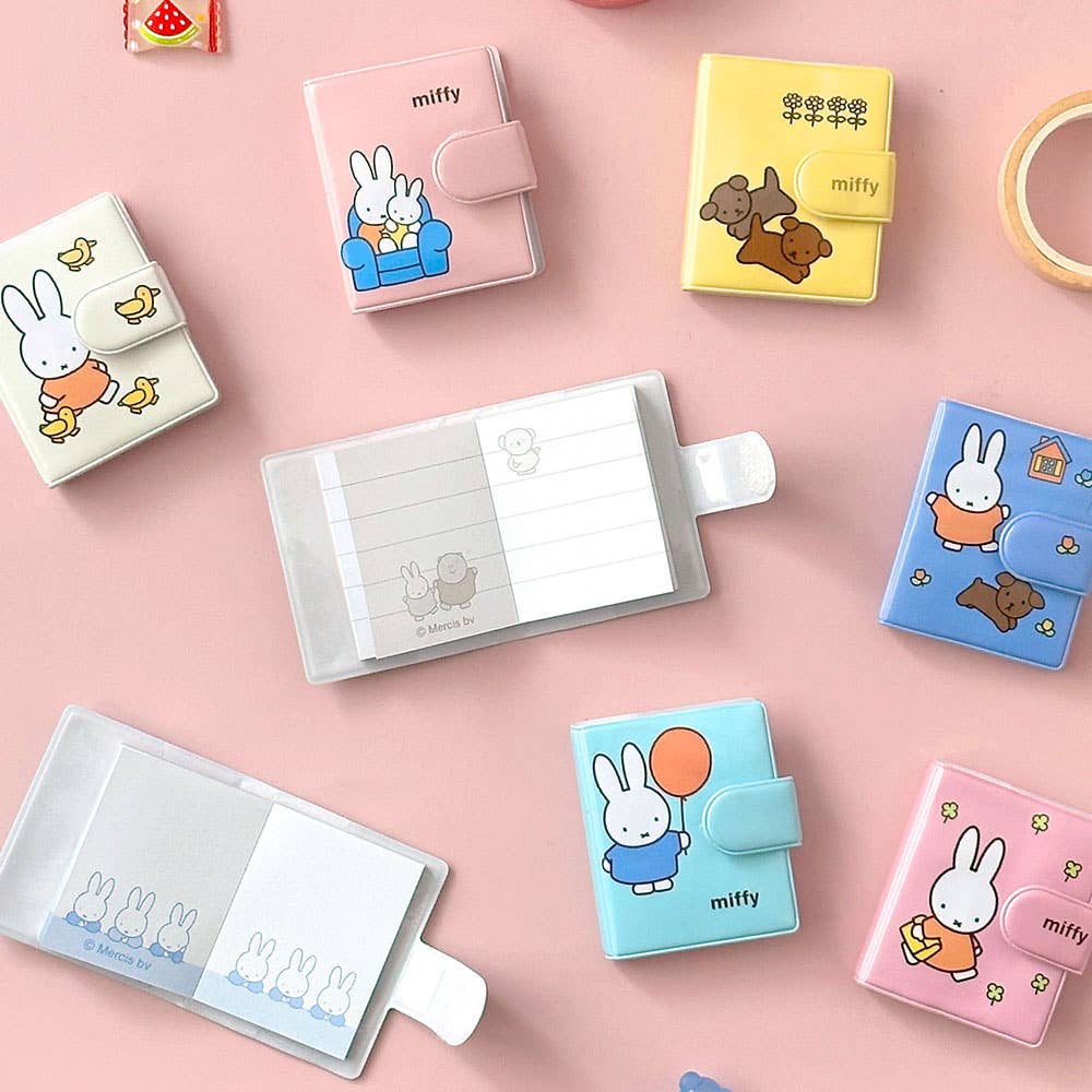 Collection of small cartoon-themed wallets and card holders on a pink background