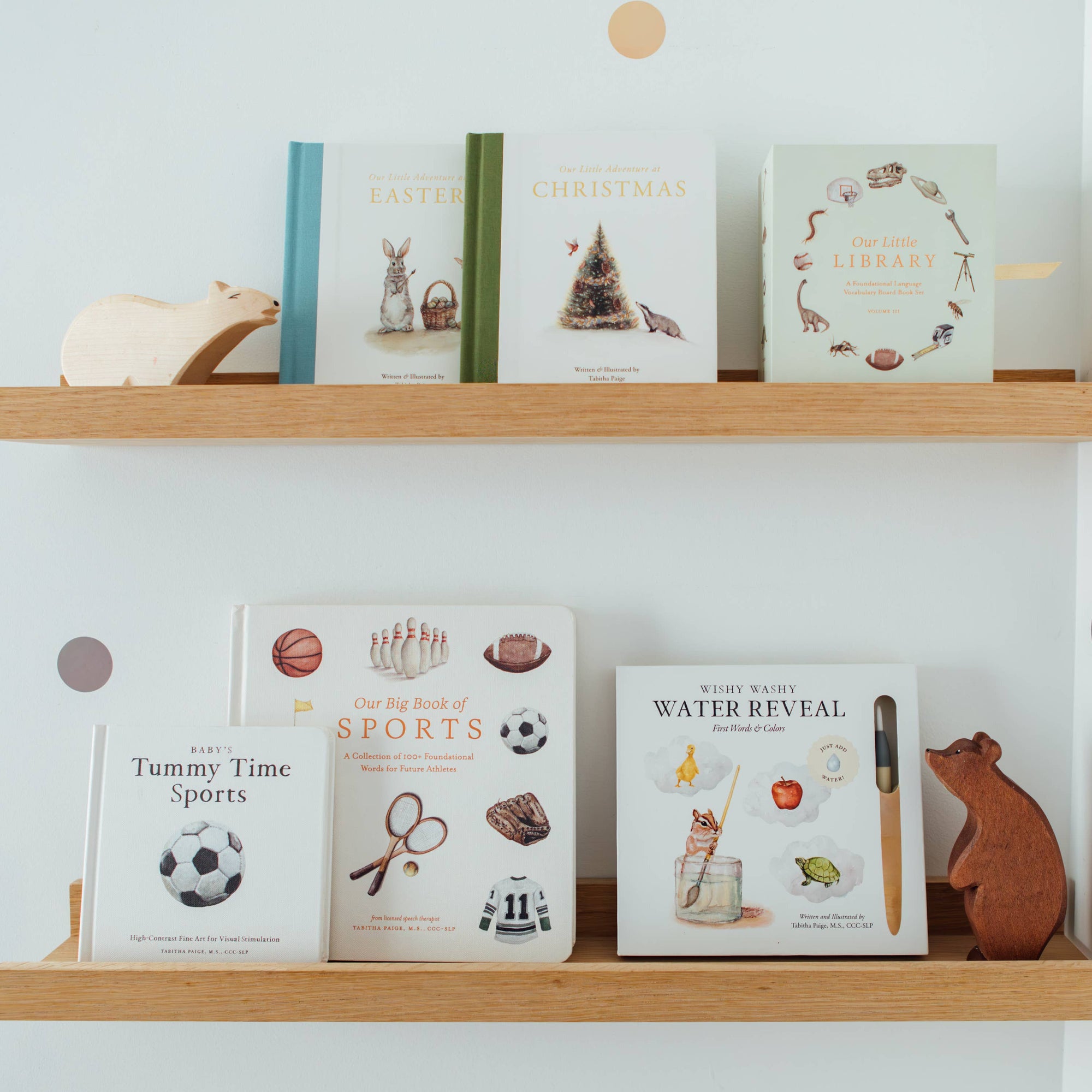Wooden shelves with children's books and toys against a light blue wall.