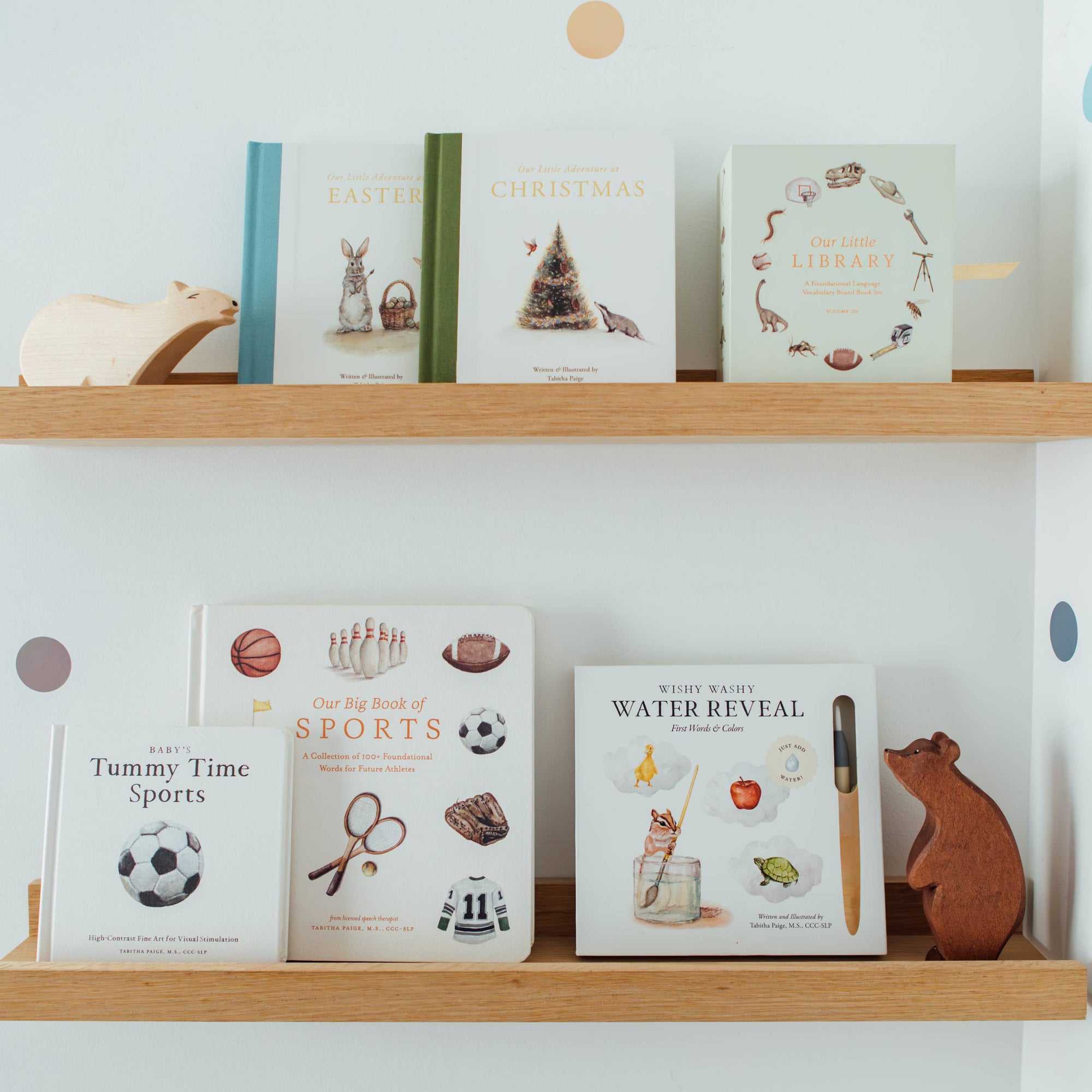 Wooden shelves with children's books and toys against a light blue wall.