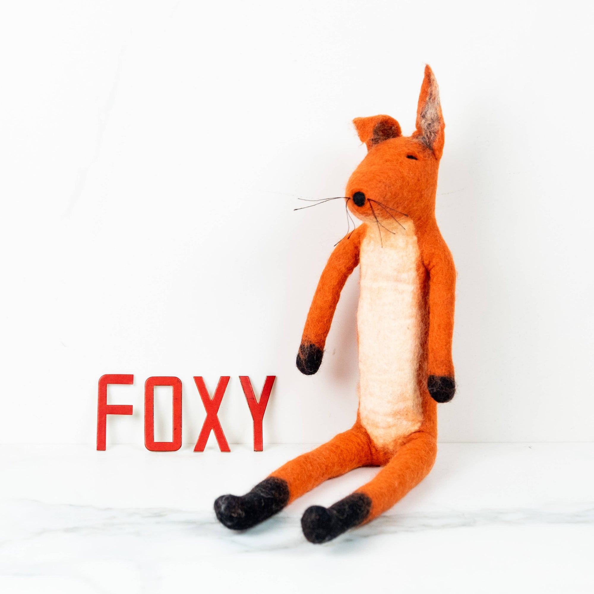 Plush fox toy with 'FOXY' text on a white background
