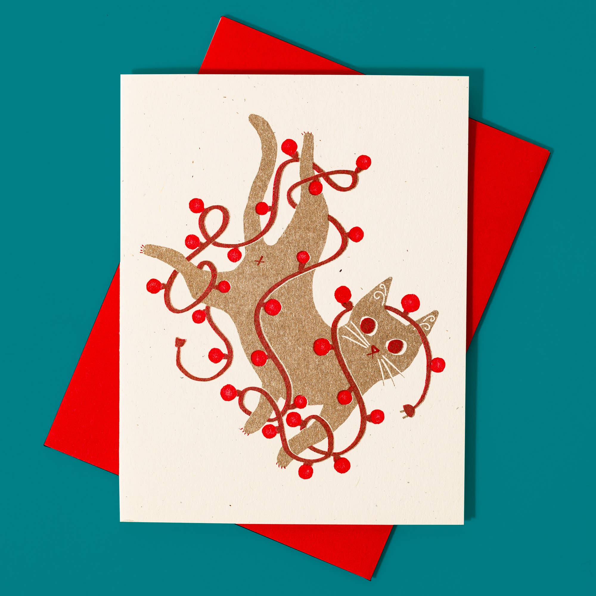 Card with cat and berry design on a red envelope against a teal background