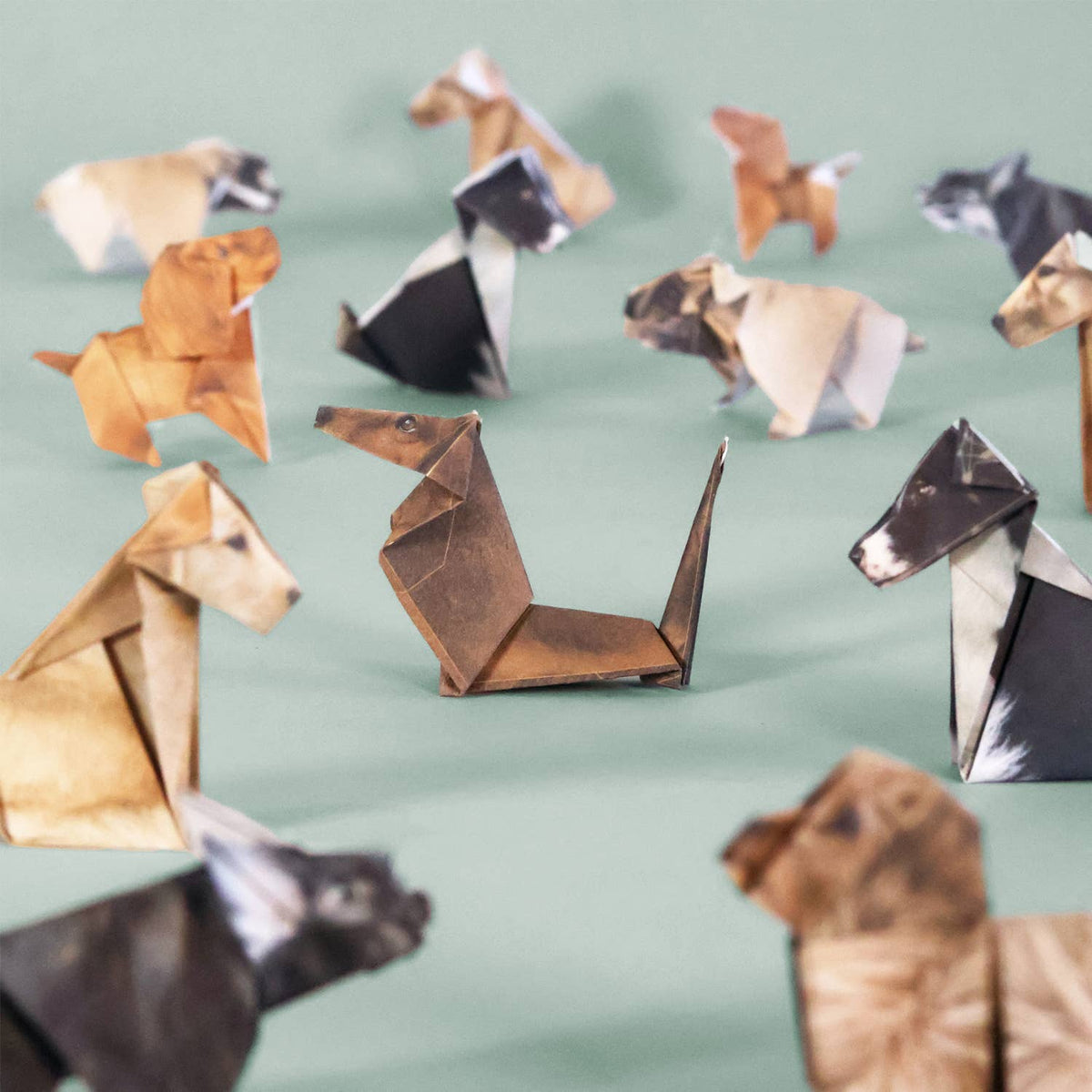 Collection of origami animals on a light green background