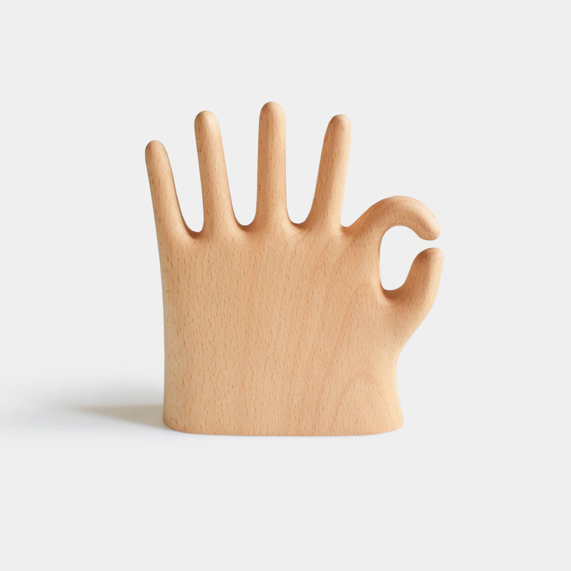 Wooden hand-shaped object on a light gray background