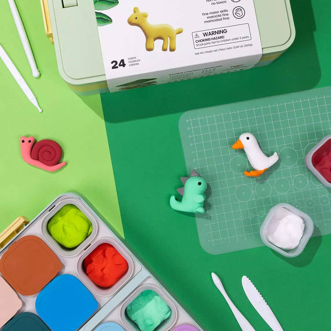 Coco Studio art kit with small figurines on a green background