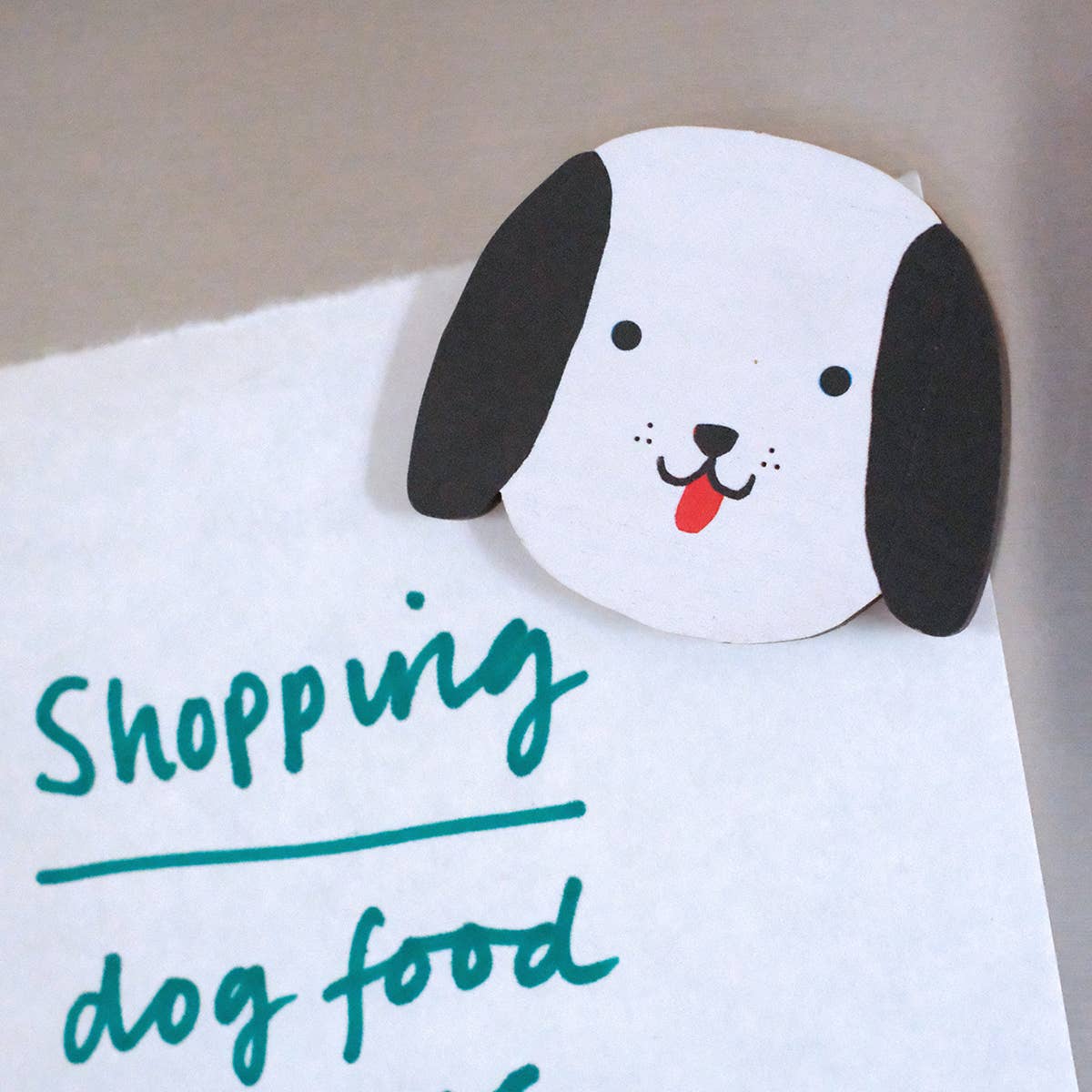 Cartoon dog face on a shopping list with 'Shopping dog food' text