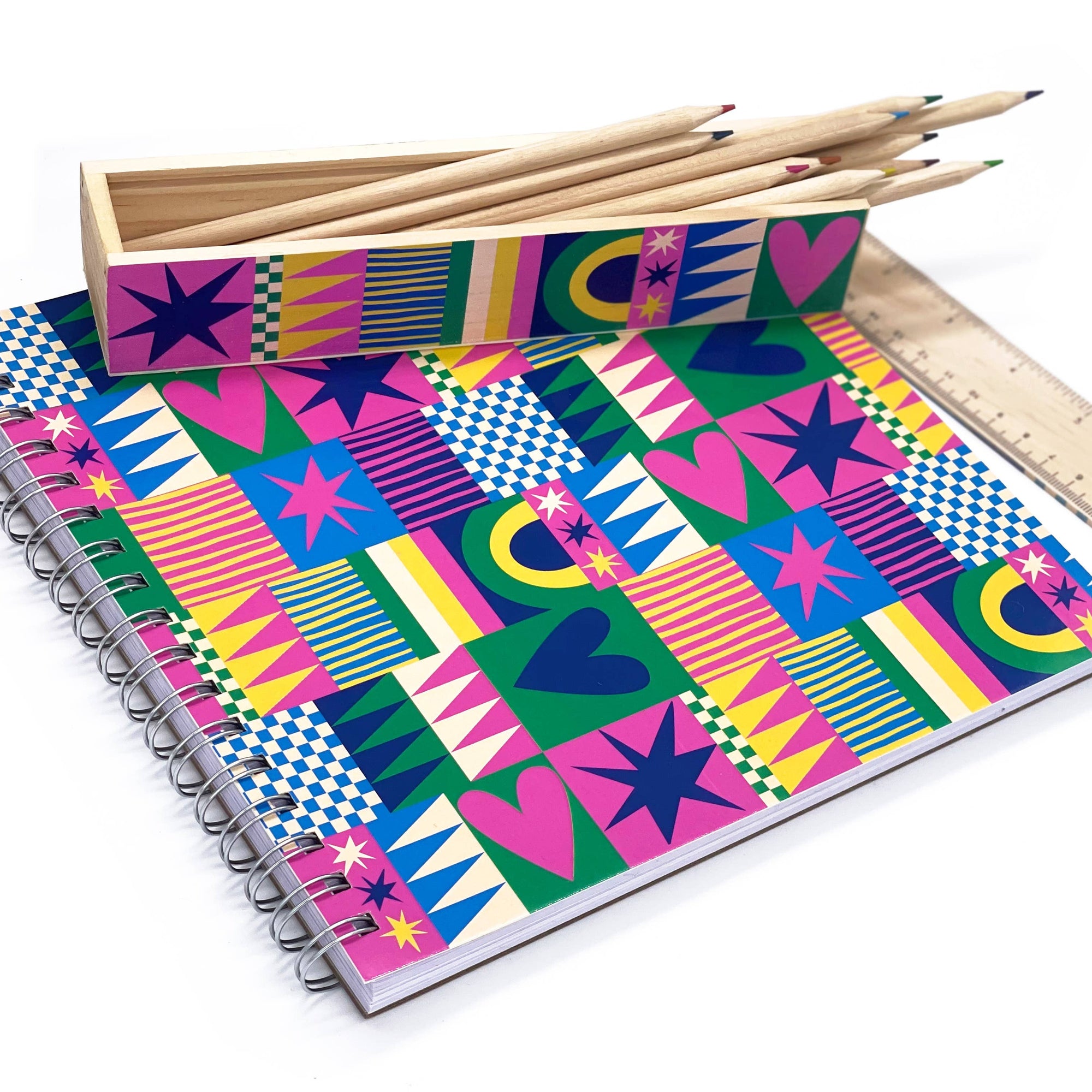 Colorful patterned notebook with pencils and a ruler on a white background