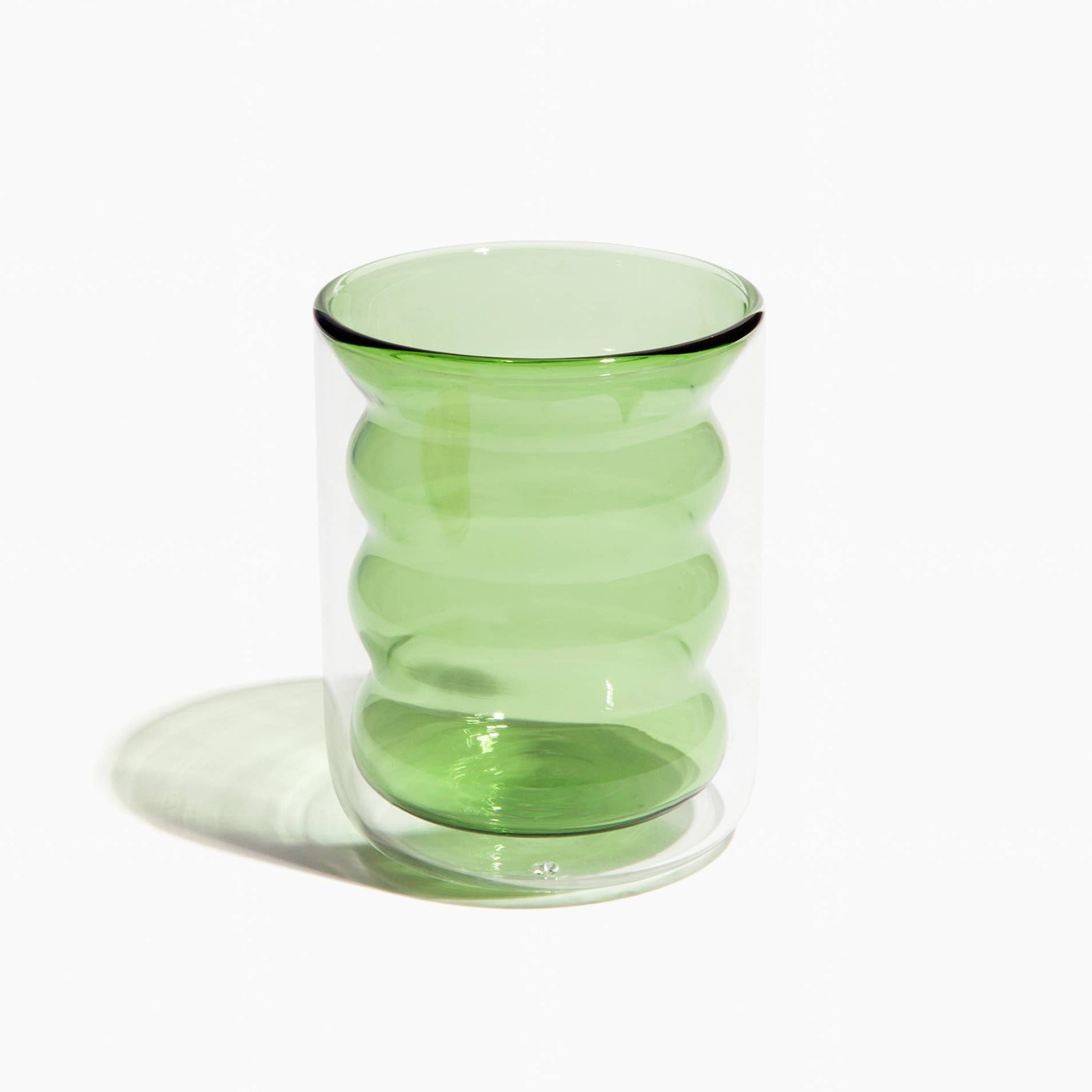Green ribbed glass vase on a white background