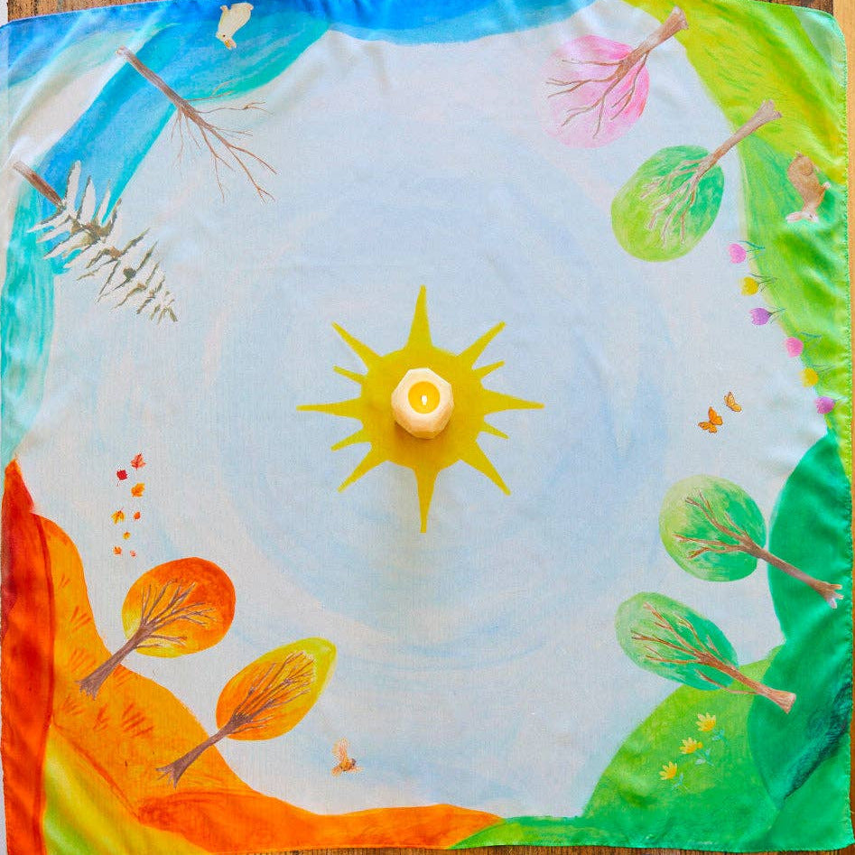 Colorful children's craft project with a sun and nature elements on a wooden surface.