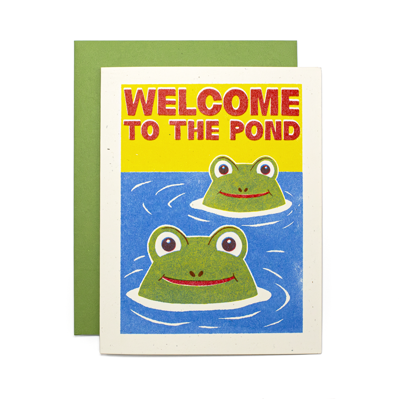 A square greeting card with a green envelope behind it, featuring a retro-style illustration of two green frogs in blue water with the text 'WELCOME TO THE POND' in red on a yellow background.