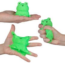 Green frog-shaped stress balls being held in hands against a white background