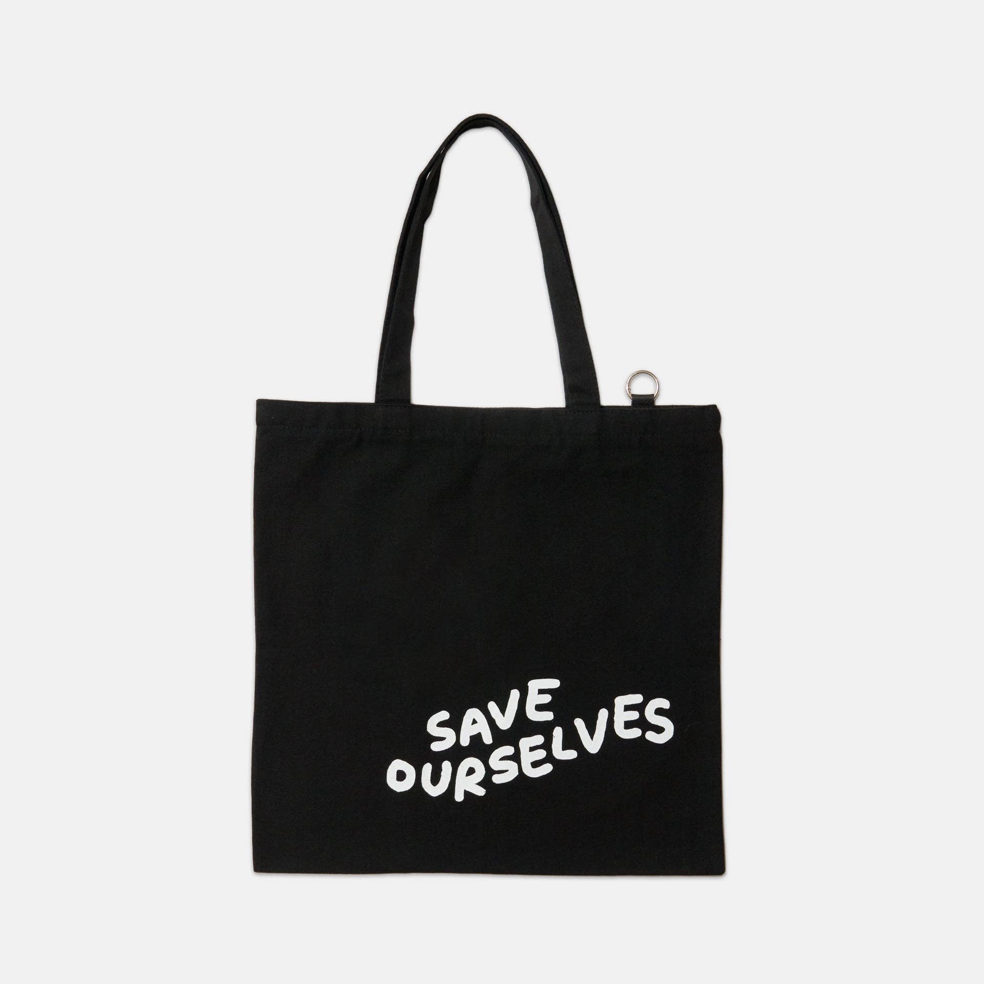 Black tote bag with 'SAVE OURSELVES' text on a white background