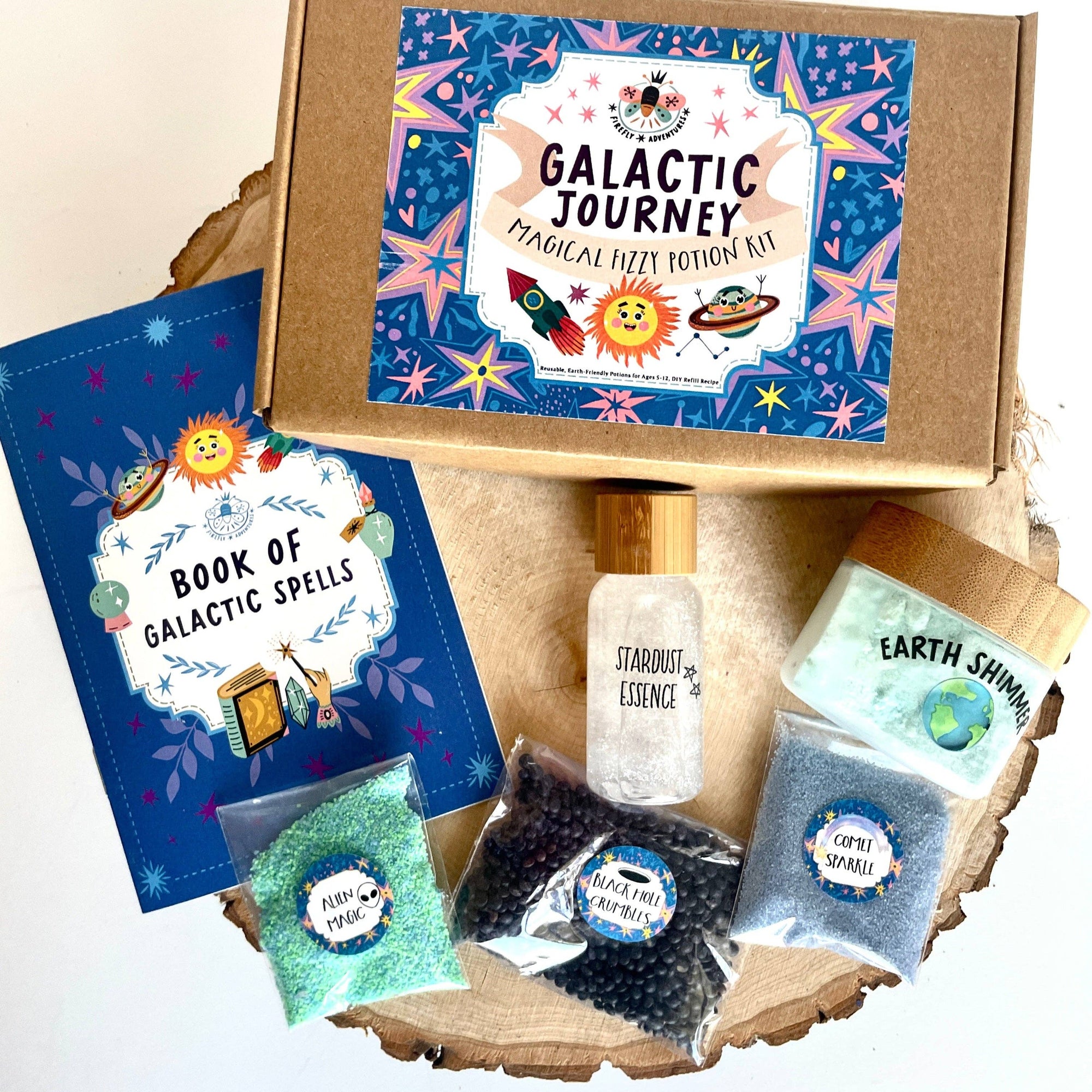 Galactic Journey magical fizz kit with a book of spells and various ingredients on a wooden surface.