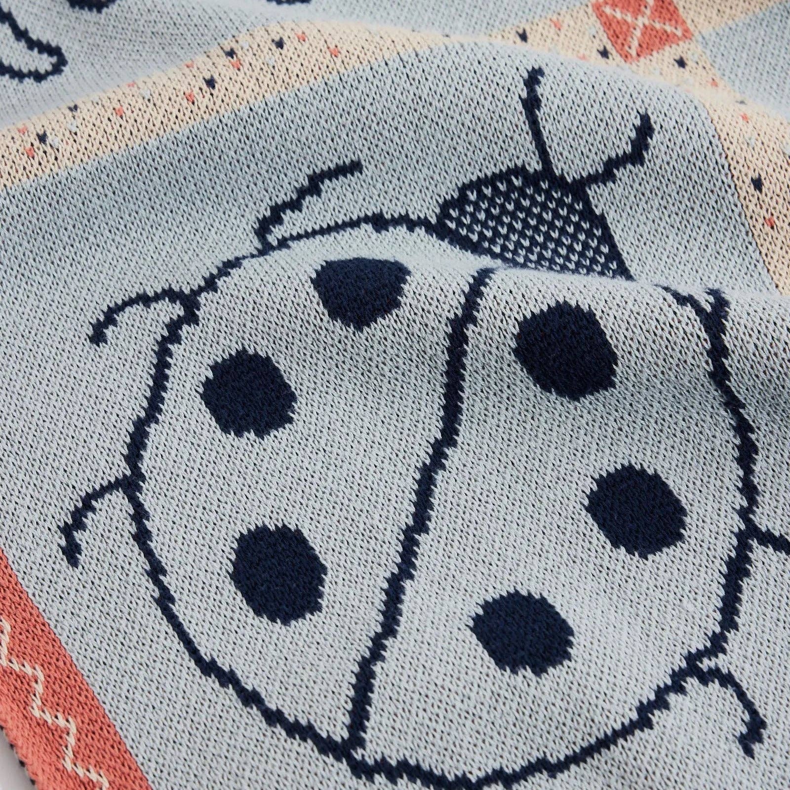 Textile with a ladybug design on a light blue background