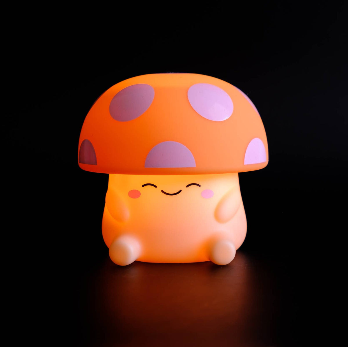 Mushroom-shaped night light with a smiling face on a black background