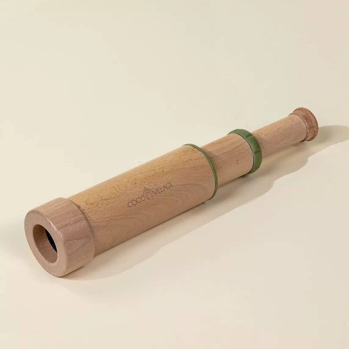 Wooden rolling pin with a green band on a beige background