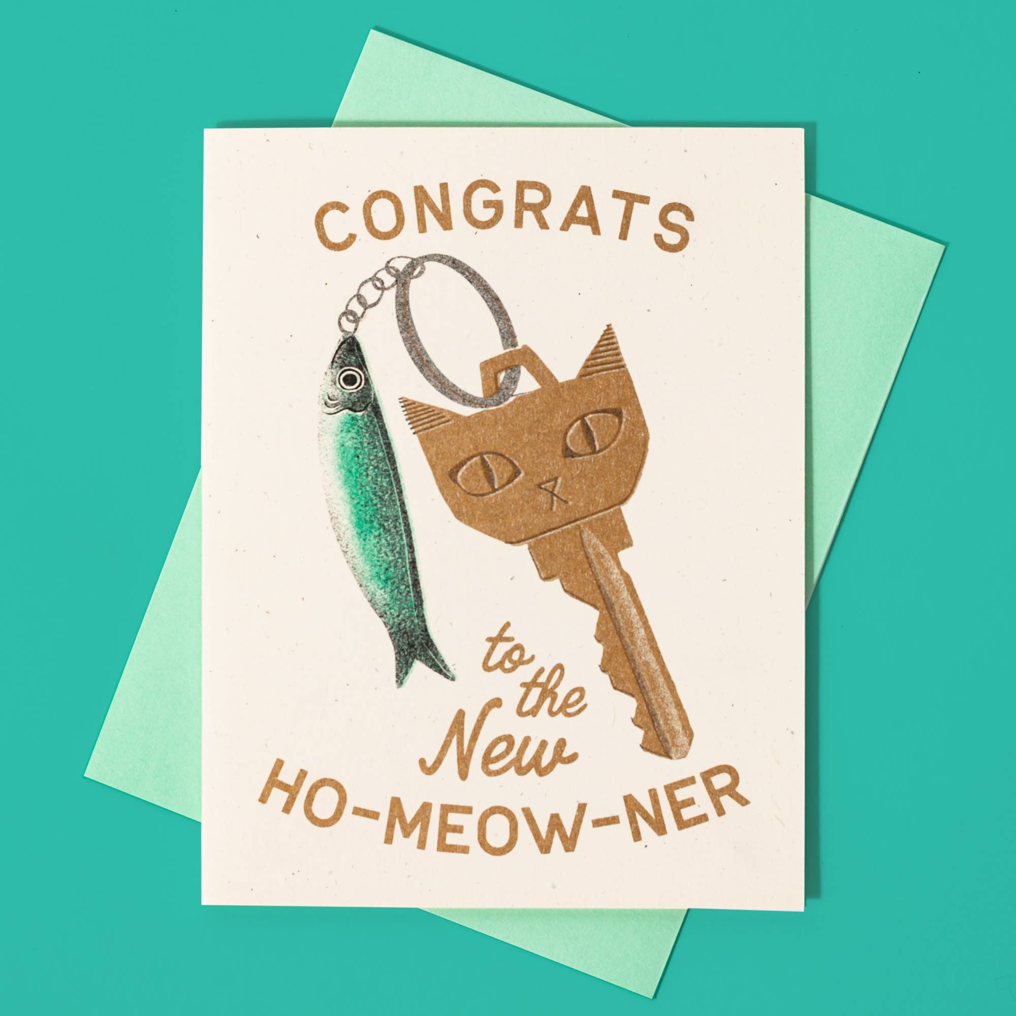 Greeting card with cat-themed key and fish illustration on a teal background
