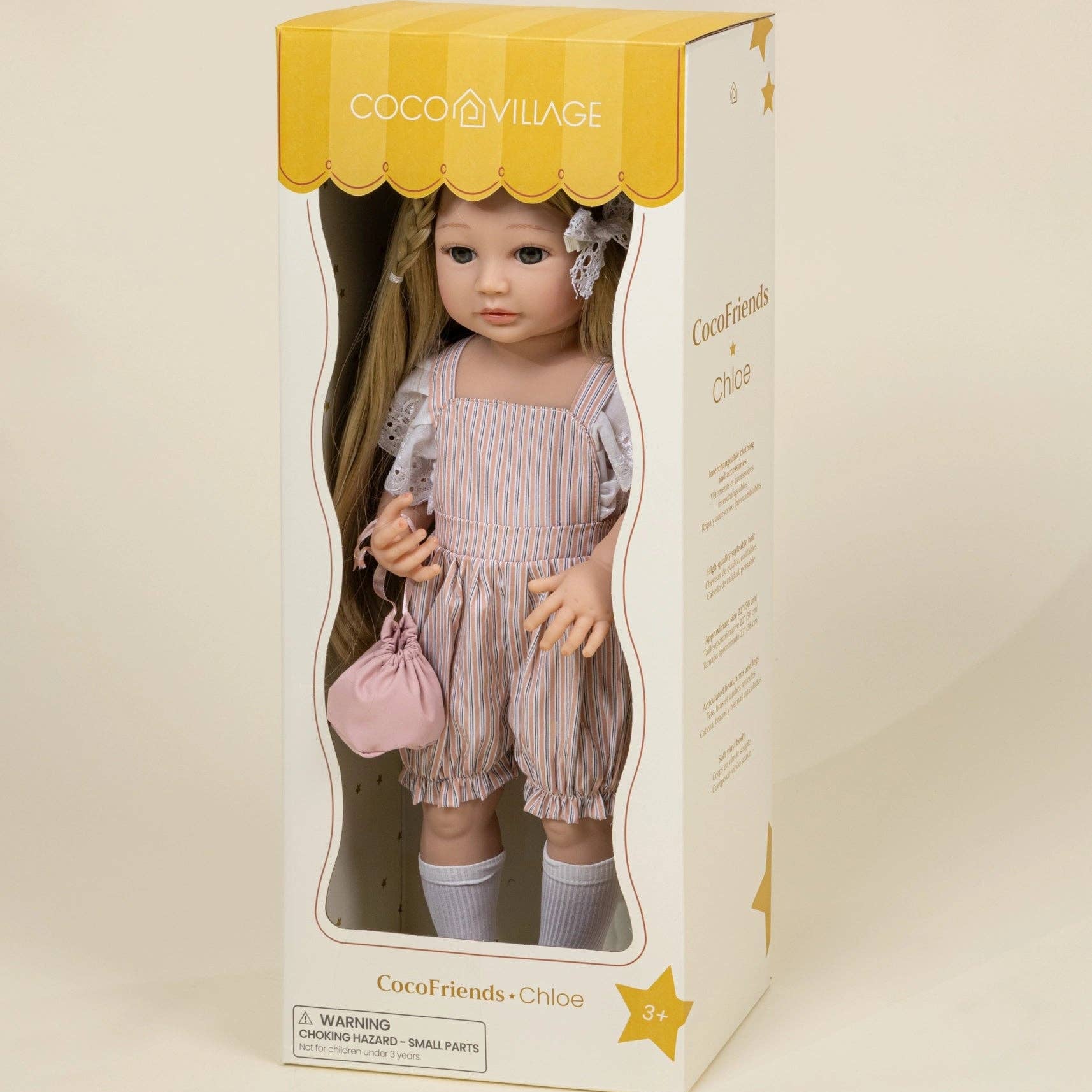 Cocochilis Village doll in a box on a beige background