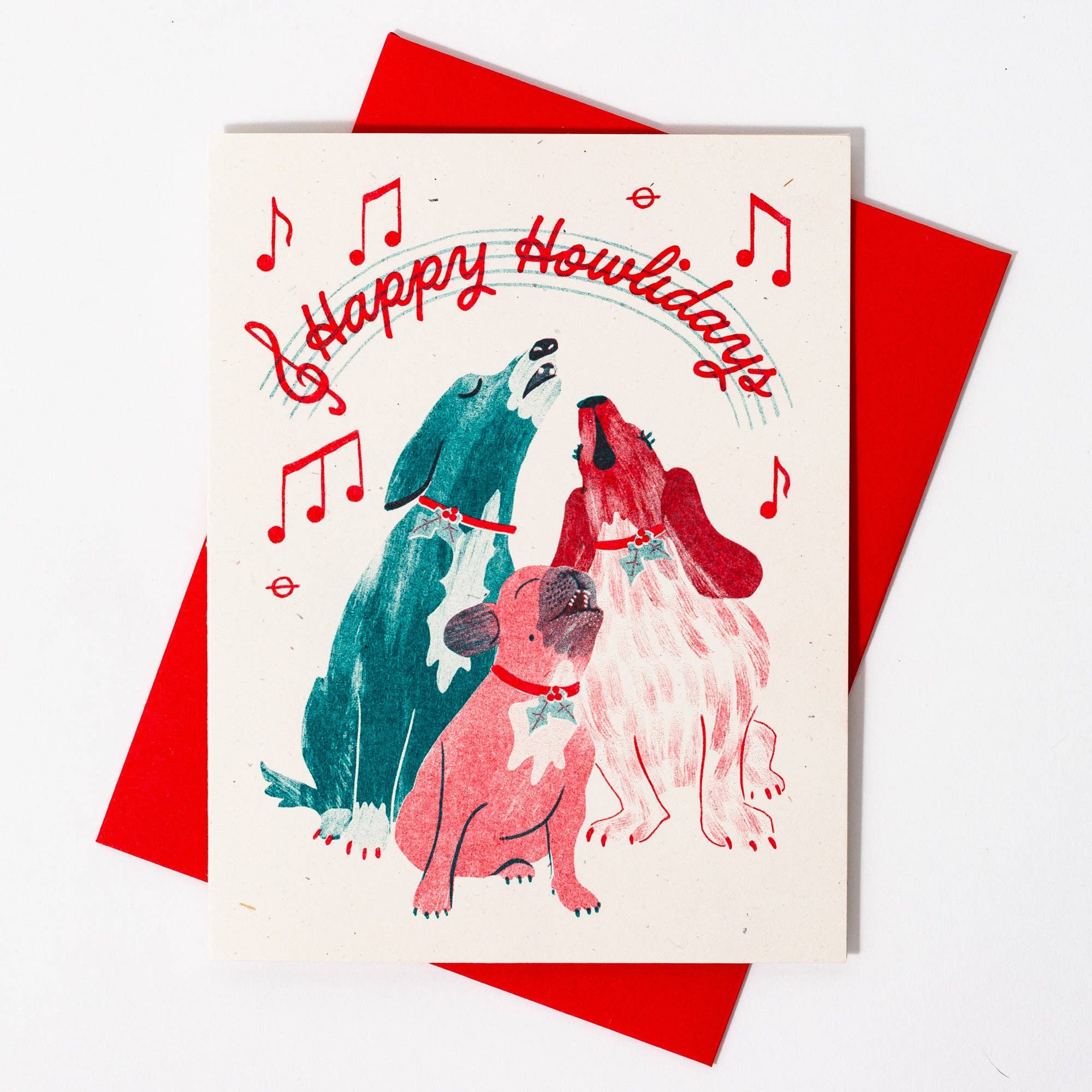 Greeting card with two dogs singing and 'Happy Howlidays' text, surrounded by red envelopes.