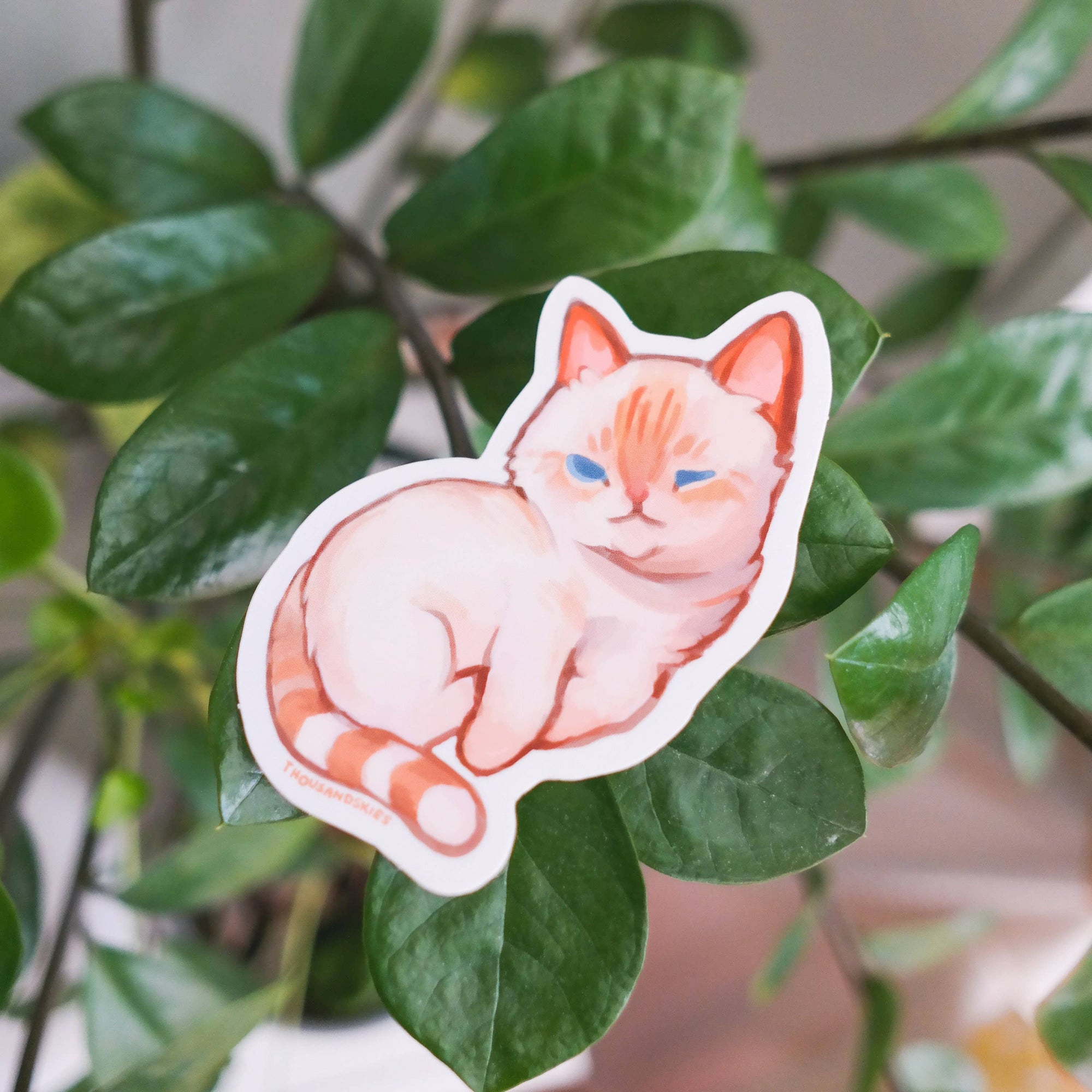 Sticker of a cat on a green leaf