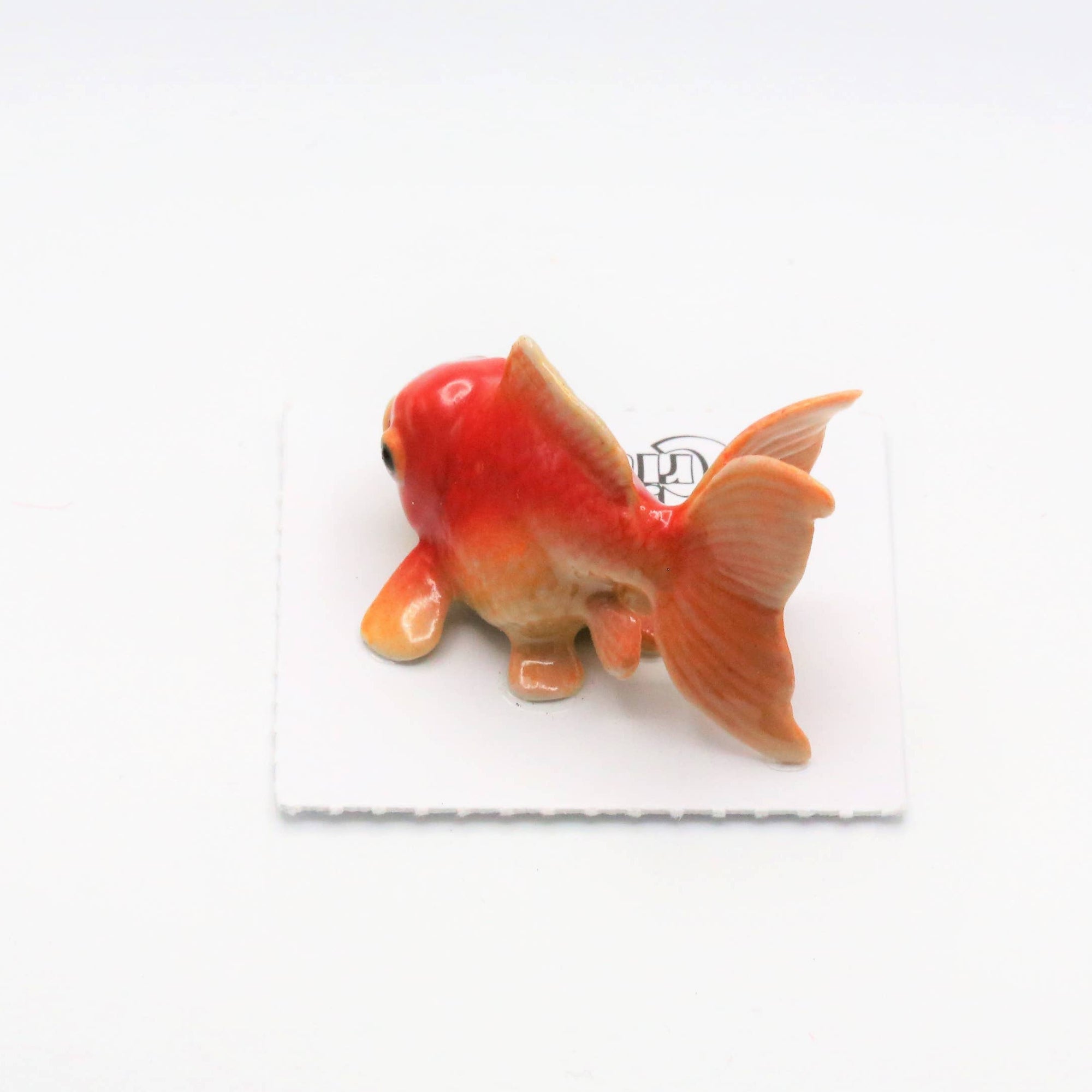 Small goldfish figurine on a white background