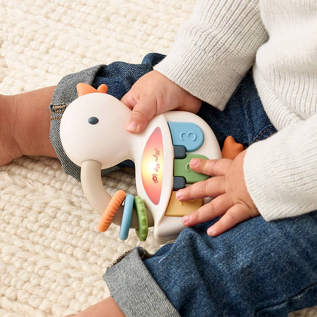 Child playing with a colorful toy piano on a textured surface