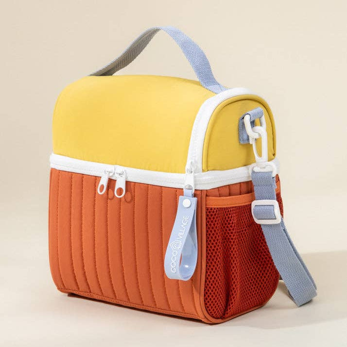 Multicolored bag with yellow top, orange bottom, and gray strap on a beige background