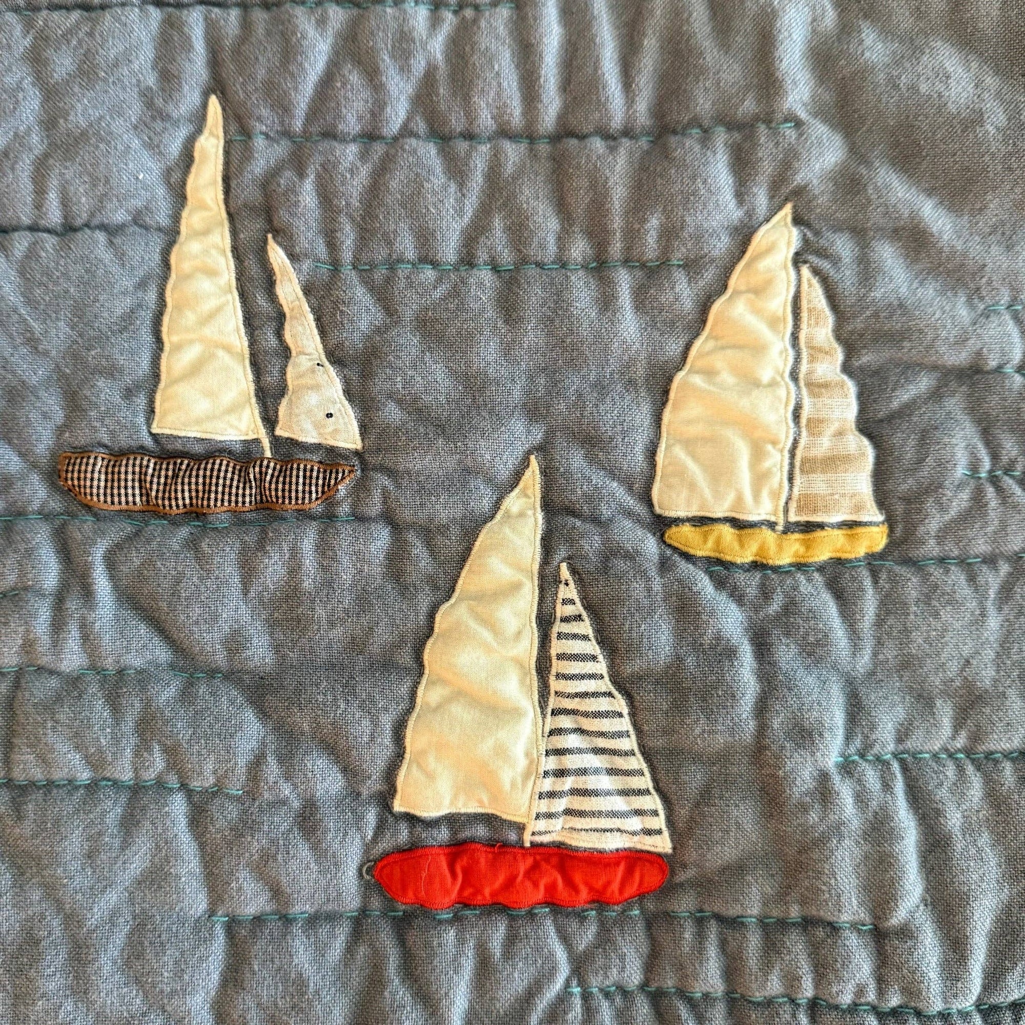 Sailboat appliqués on a textured fabric background